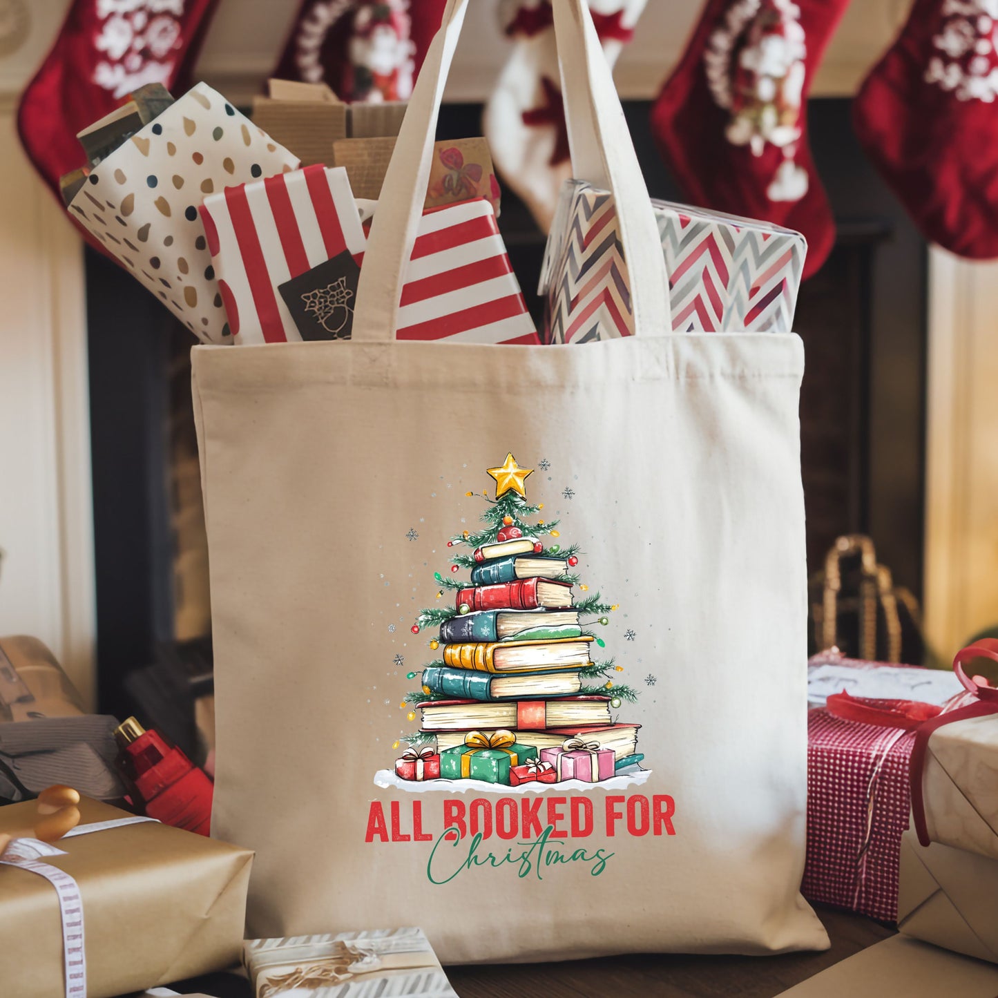 Canvas tote bag with a Christmas tree made of colorful books and the text “All Booked For Christmas" shown on Christmas themed background