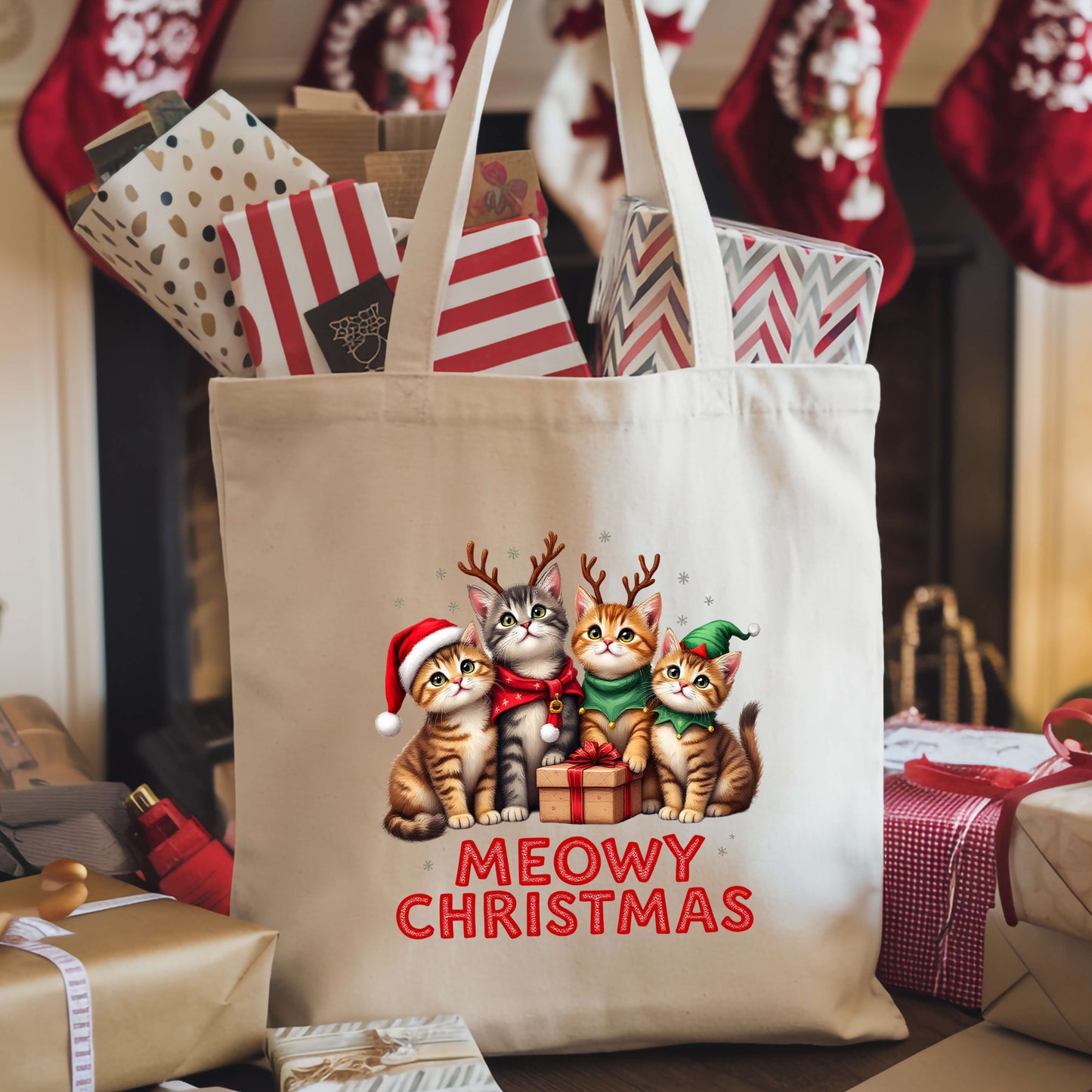 Canvas tote bag with four cats dressed in Christmas outfits around a gift and the words “Meowy Christmas.”
