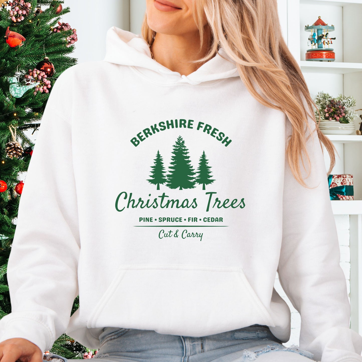 Model wearing white Berkshire Fresh Christmas Trees hoodie with holiday tree farm graphic on the front