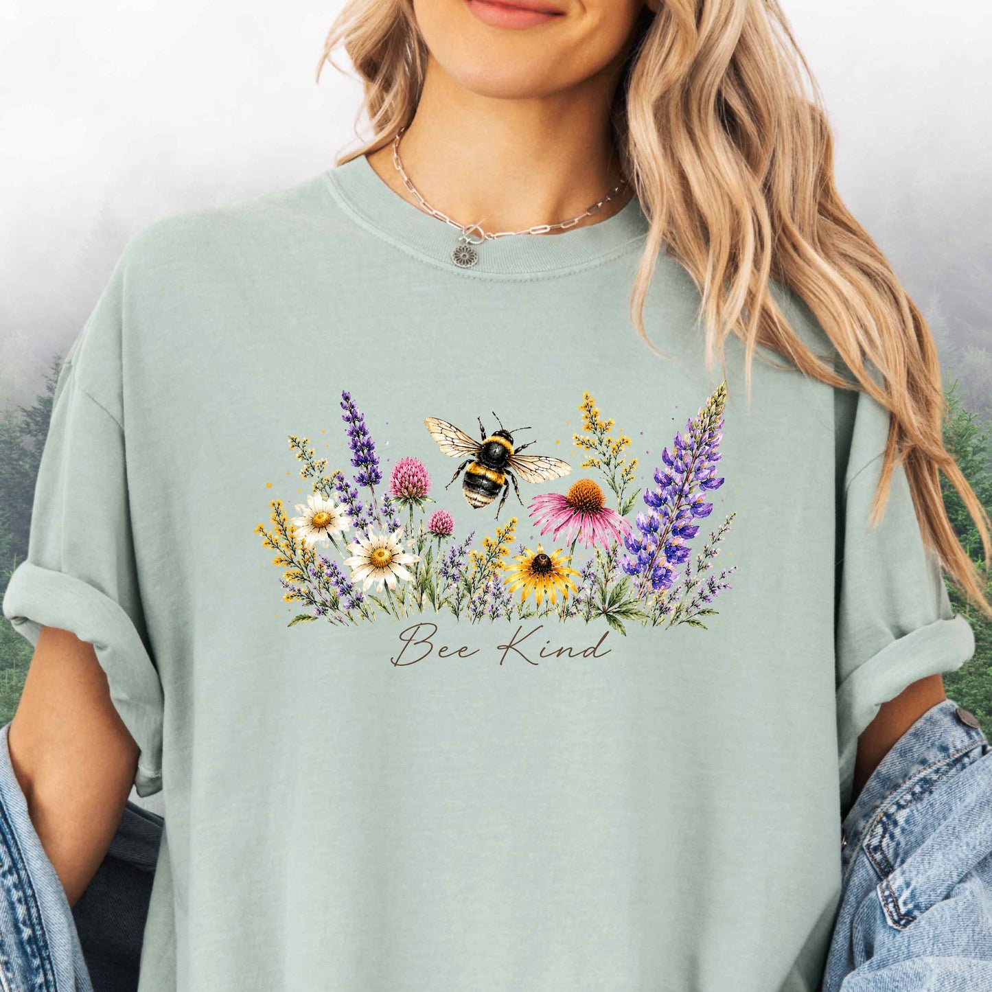 Person wearing Bee Kind Comfort Colors t-shirt with watercolor bee and wildflowers in the color bay.