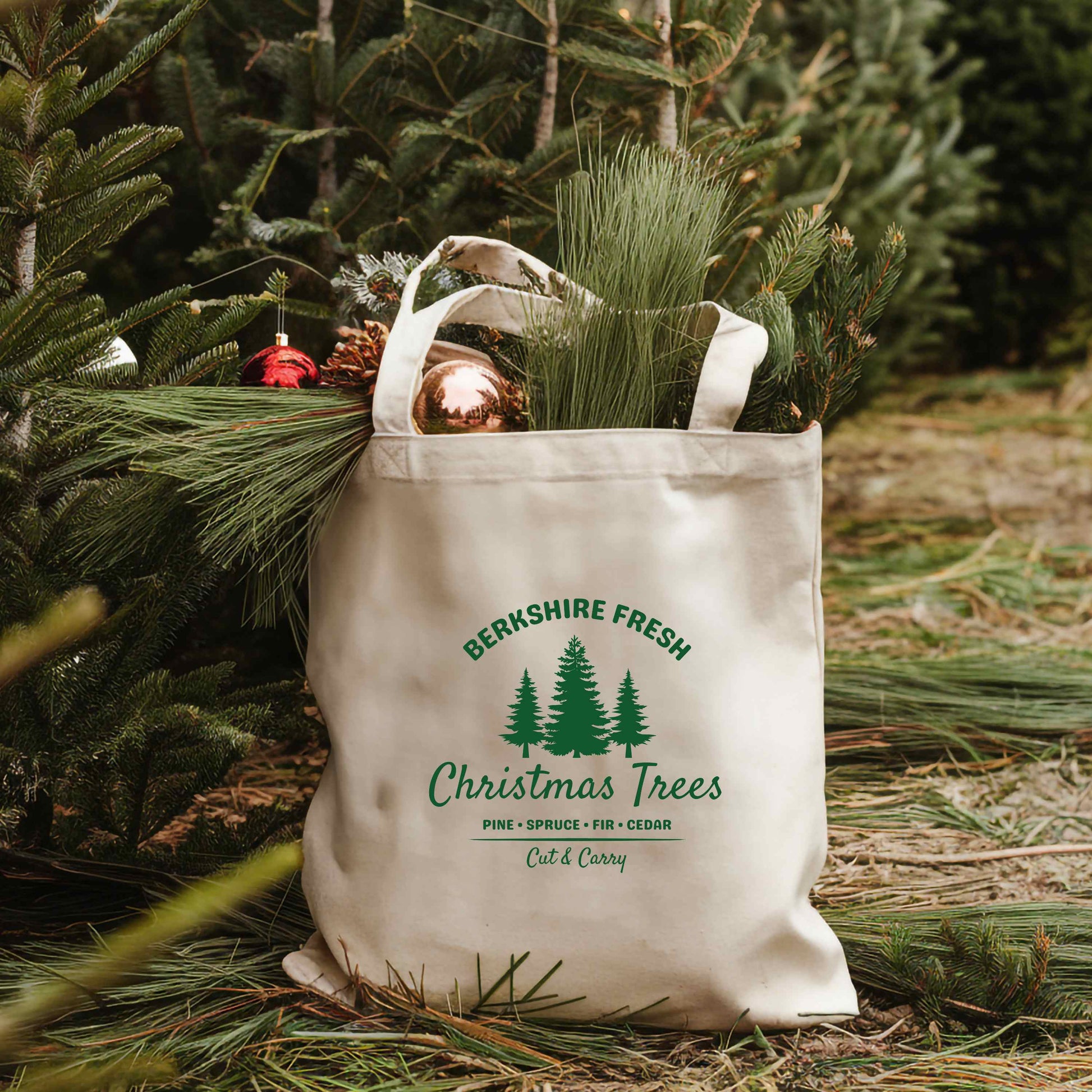 Tote bag with 'Berkshire Fresh Christmas Trees' design filled with Christmas greens.