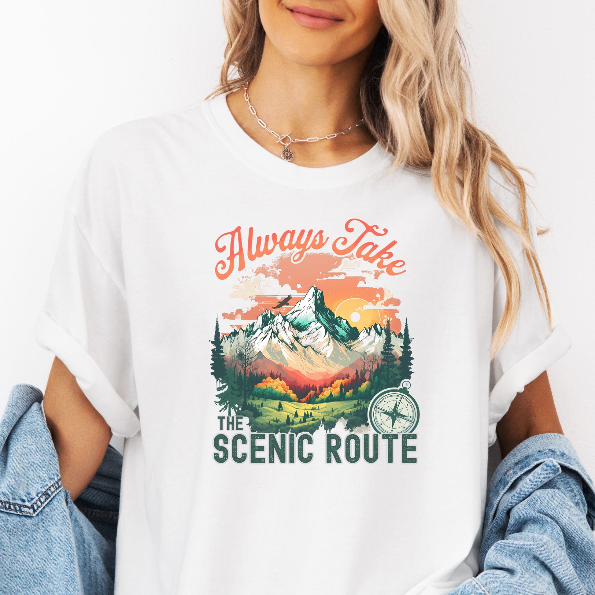 Person wearing a Comfort Colors T-shirt  in the color White with a nature-inspired “Always Take the Scenic Route” design on the front.