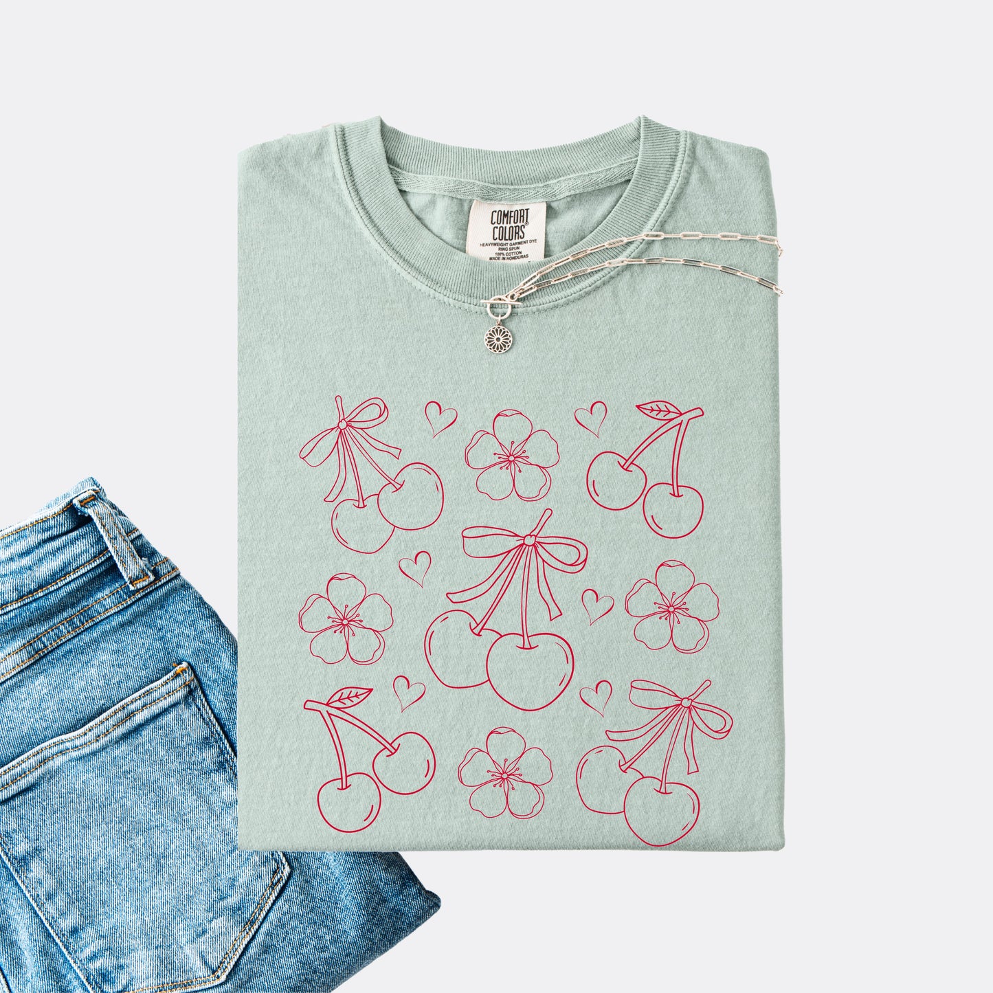 Comfort Colors shirt in the color bay with graphic of cherries, cherry blossoms and hearts, red ink.