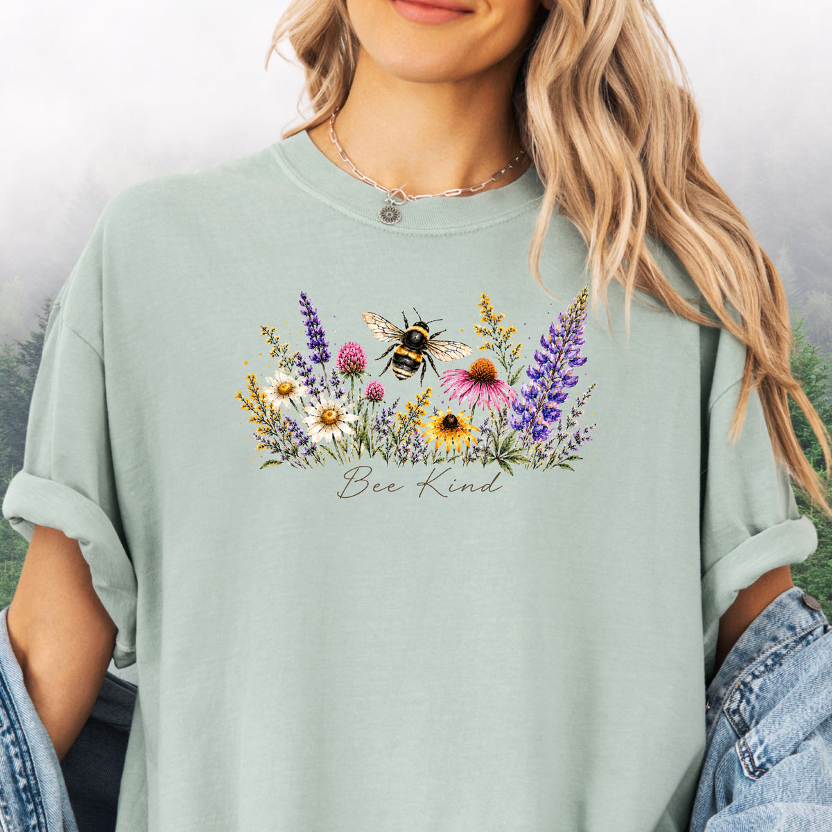 Person wearing Bee Kind Comfort Colors t-shirt with watercolor bee and wildflowers in the color bay.