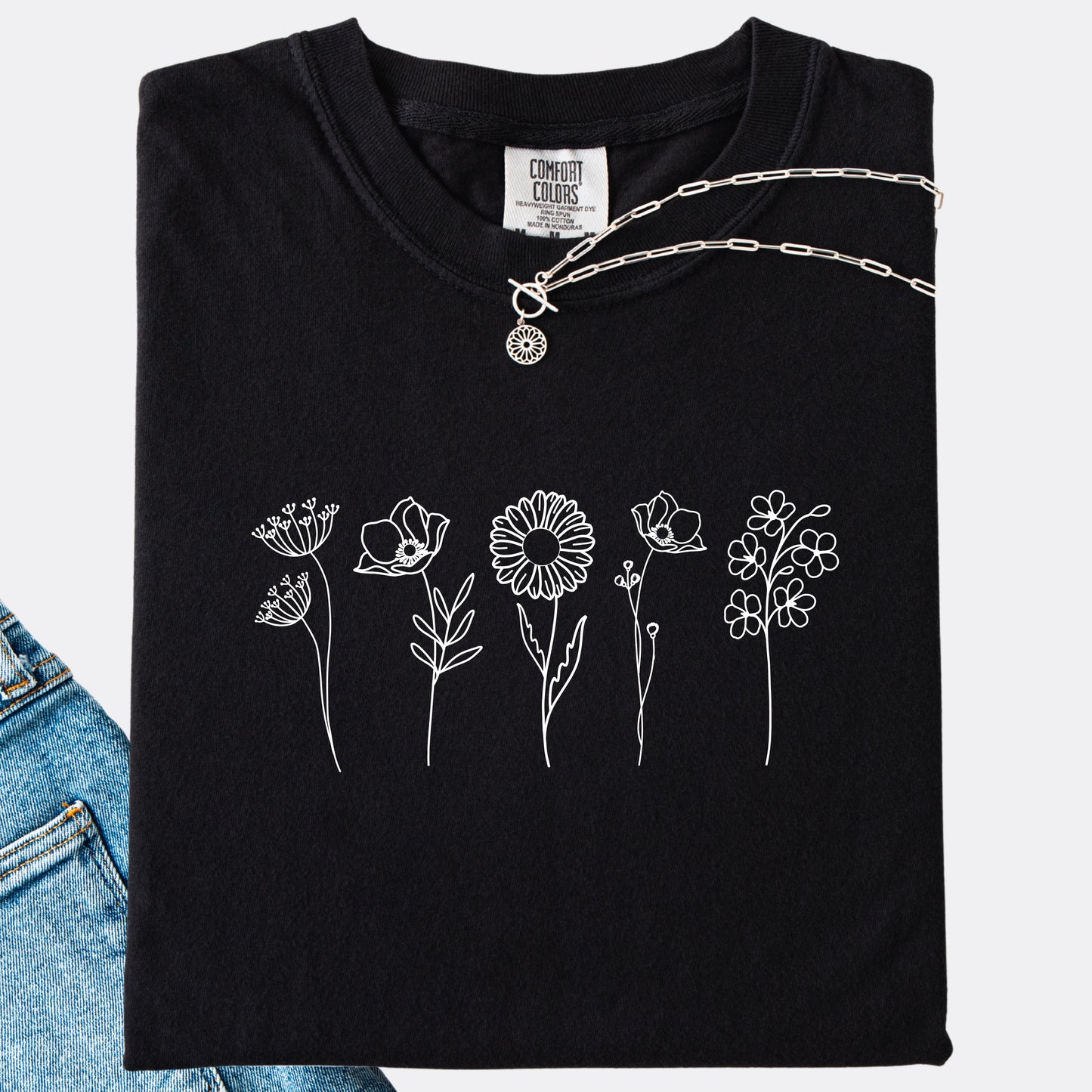 Comfort Colors black T-shirt featuring a minimalist white line art design of six different wildflowers.