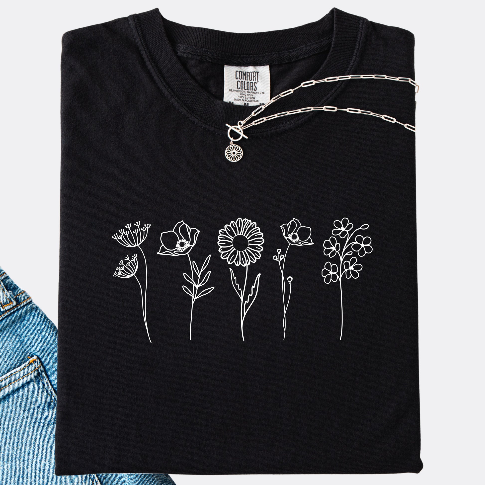 Comfort Colors black T-shirt featuring a minimalist white line art design of six different wildflowers.