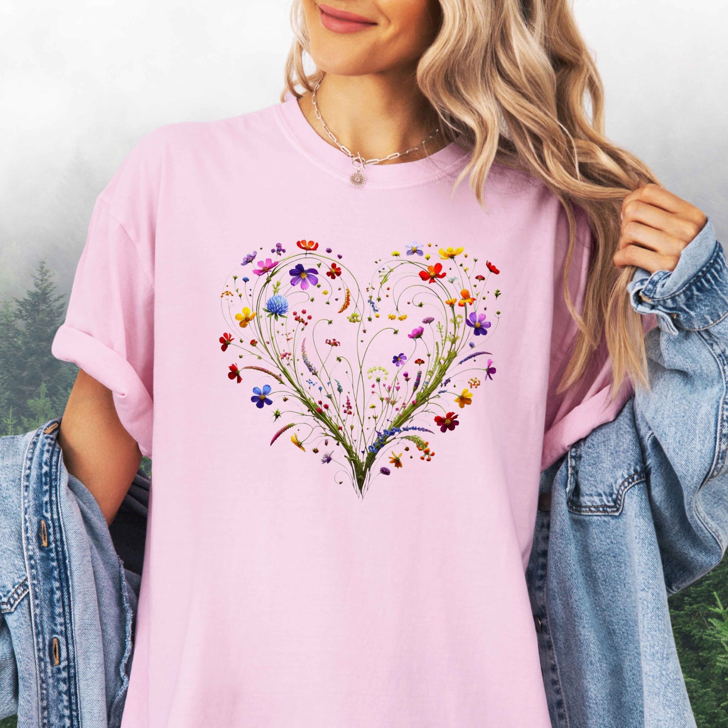 Person wearing a blossom colored shirt with a wildflower heart graphic
