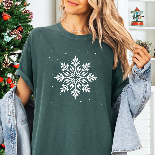 Person wearing a Comfort Colors tshirt with snowflake design in the color blue spruce