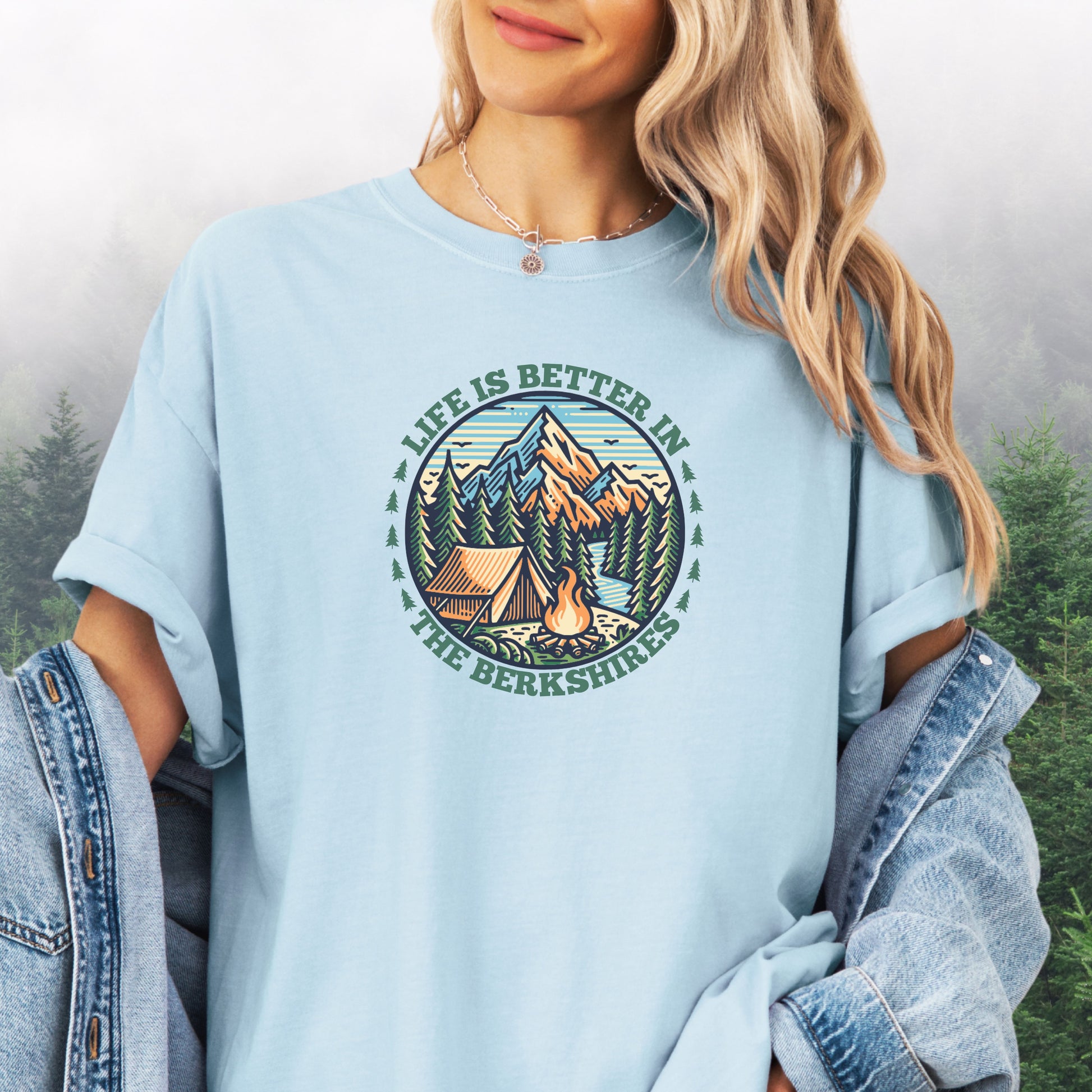 Person wearing chambray colored Comfort Colors shirt with mountain design and the text: Life Is Better In The Berkshires