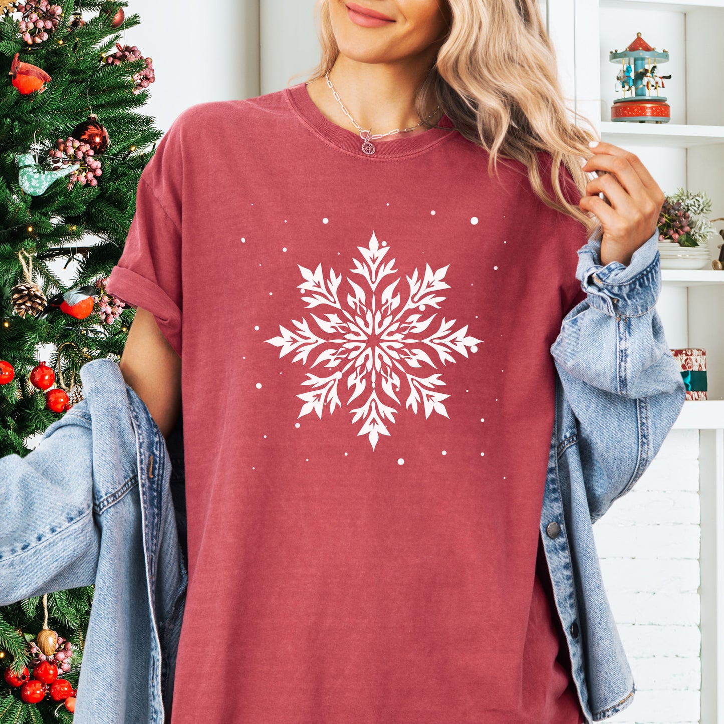Person wearing a Comfort Colors tshirt with snowflake design in the color crimson