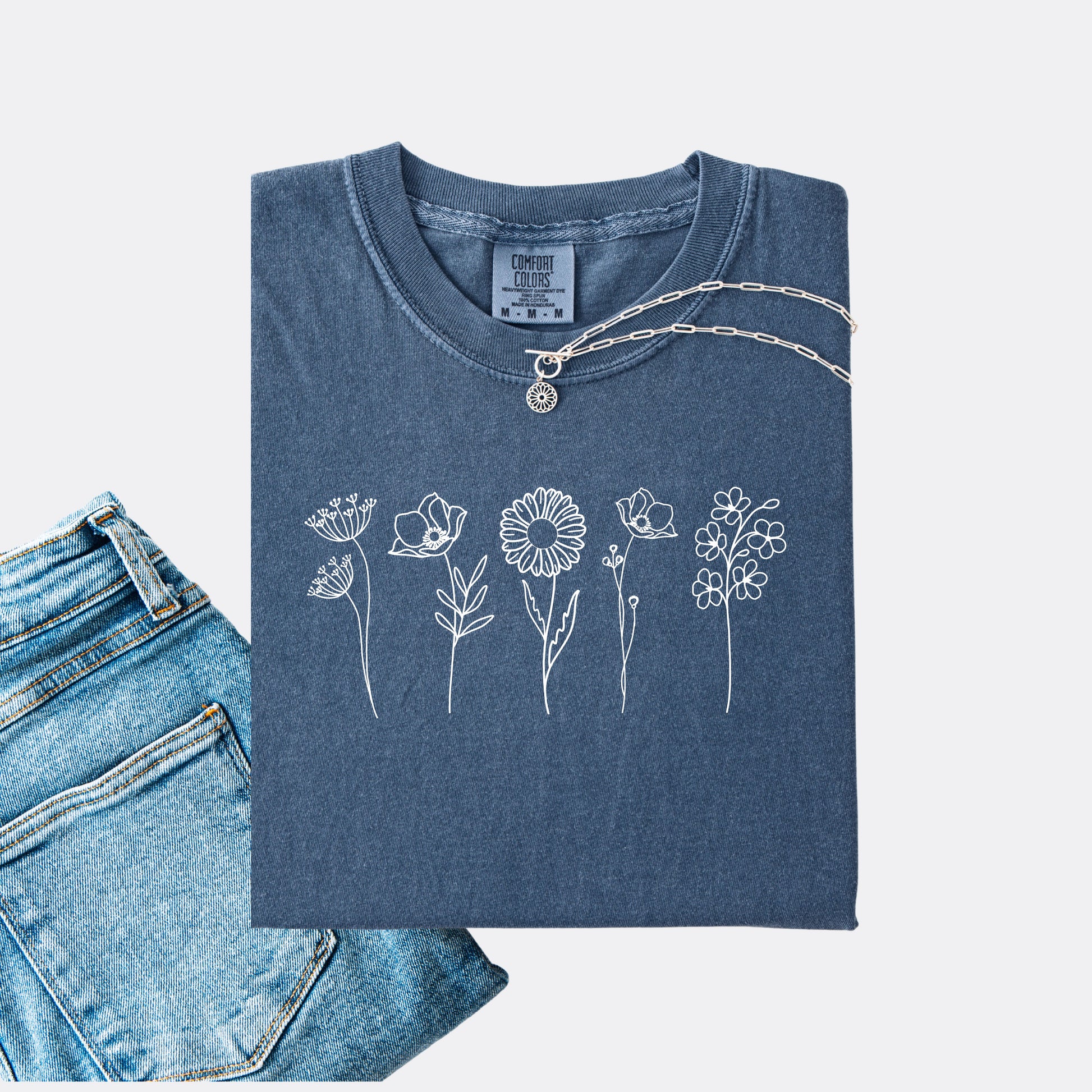 Comfort Colors denim T-shirt featuring a minimalist white line art design of six different wildflowers.