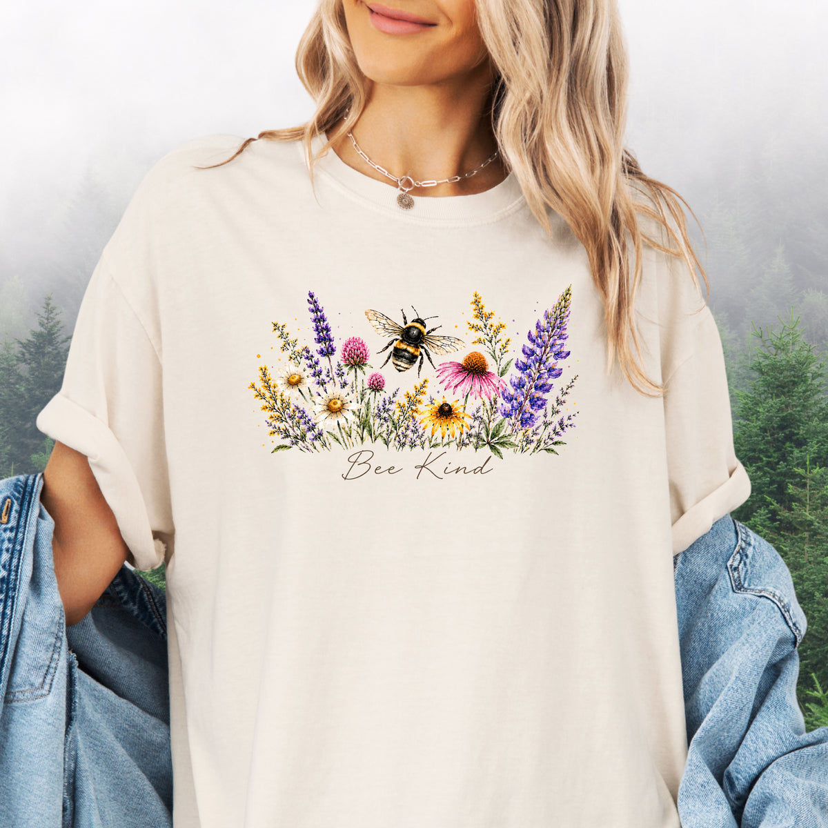 Person wearing Bee Kind Comfort Colors t-shirt with watercolor bee and wildflowers in the color ivory
