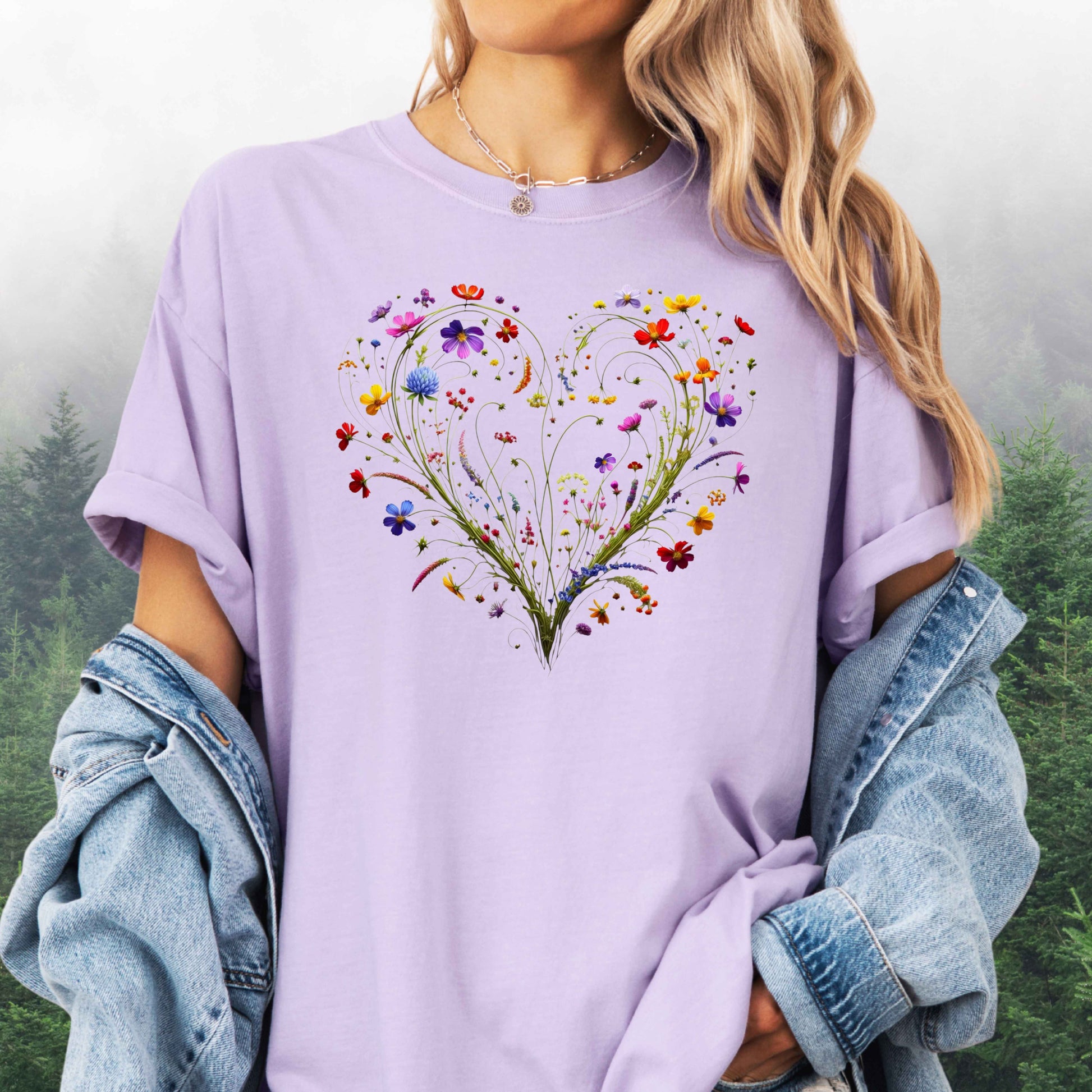 Person wearing an orchid colored shirt with a wildflower heart graphic