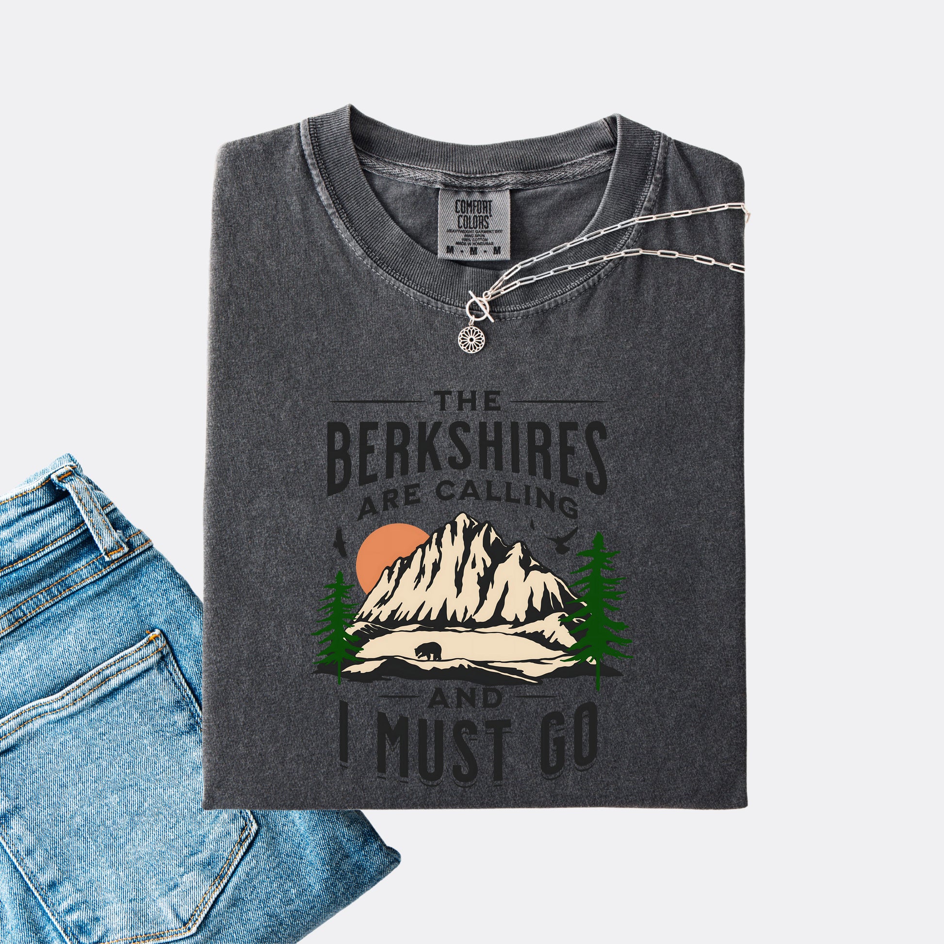 Comfort Colors 1717 T-shirt in the color pepper. Shirt features a graphic design of mountains, pine trees, and a bear with the text ‘The Berkshires are calling and I must go.’”