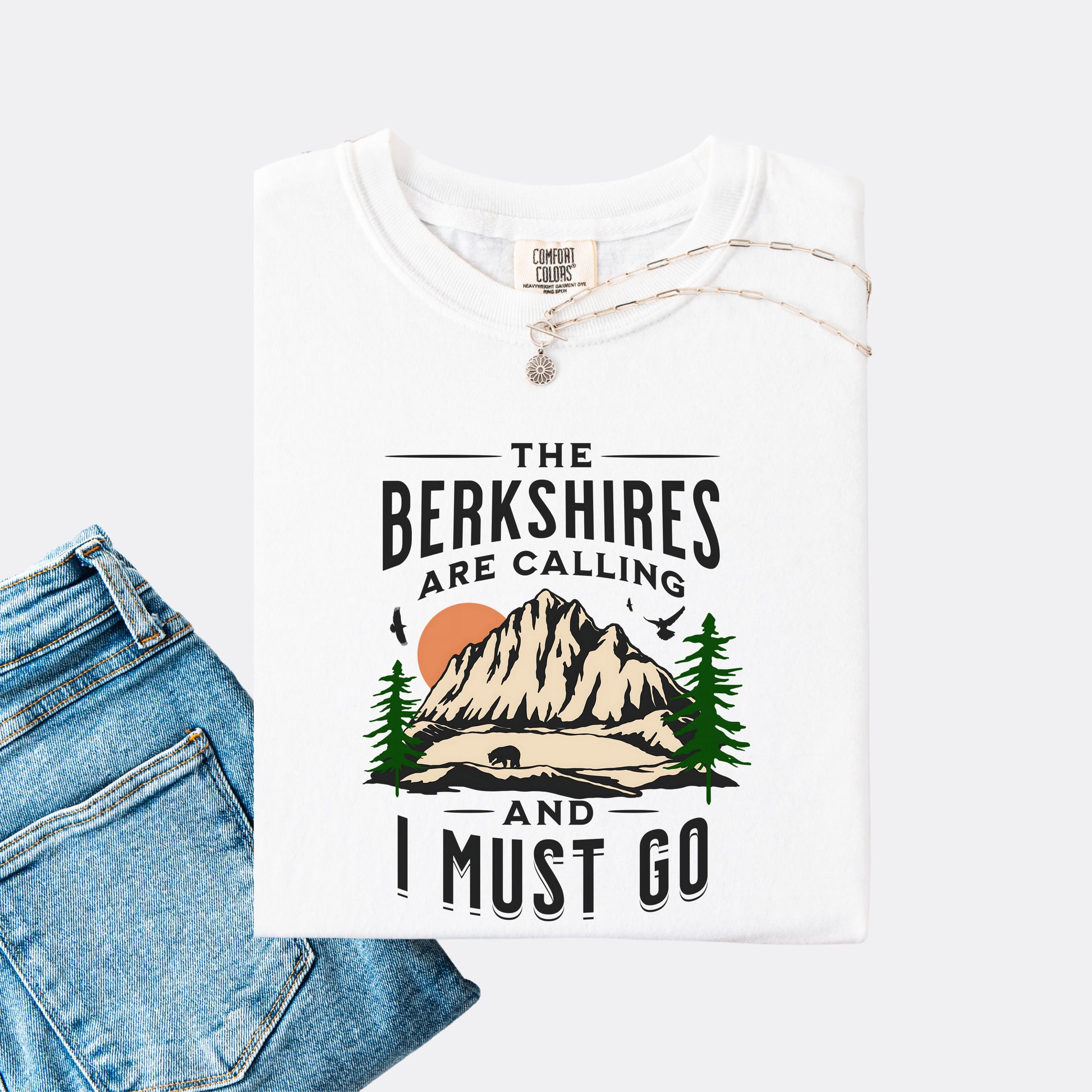 Comfort Colors 1717 T-shirt in the color white. Shirt features a graphic design of mountains, pine trees, and a bear with the text ‘The Berkshires are calling and I must go.’”
