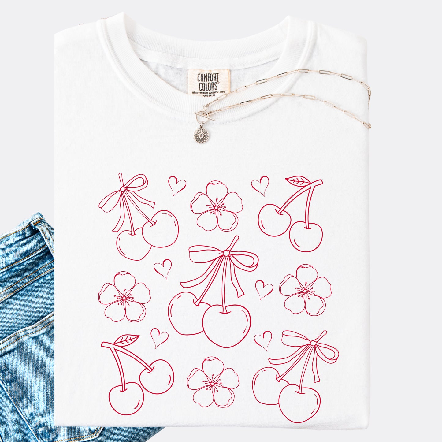 Comfort Colors shirt in white with graphic of cherries, cherry blossoms and hearts, red ink.