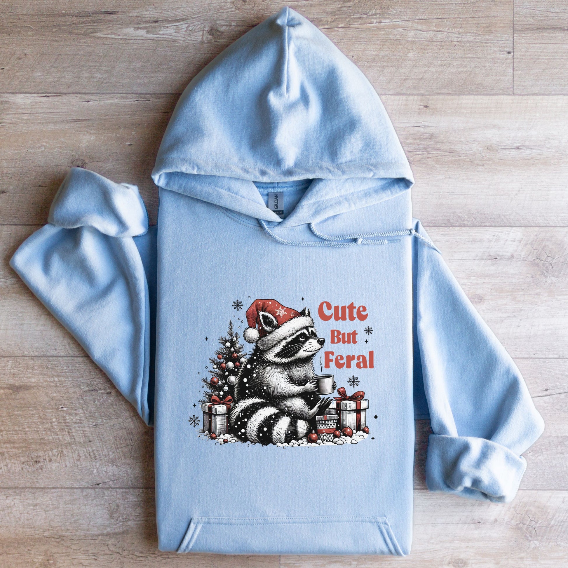 Cute But Feral Hooded Sweatshirt with racoon flat lay light blue color