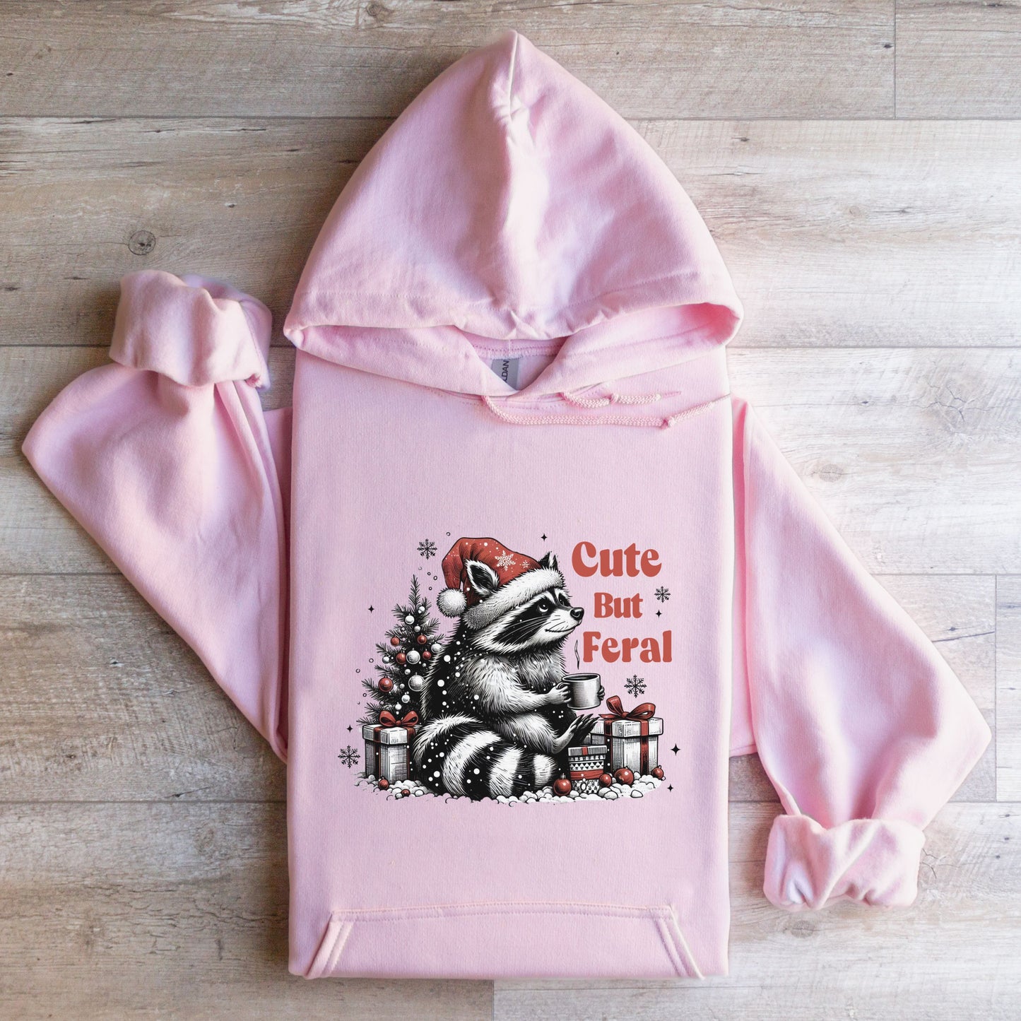 Cute But Feral Hooded Sweatshirt with racoon flat lay light pink color