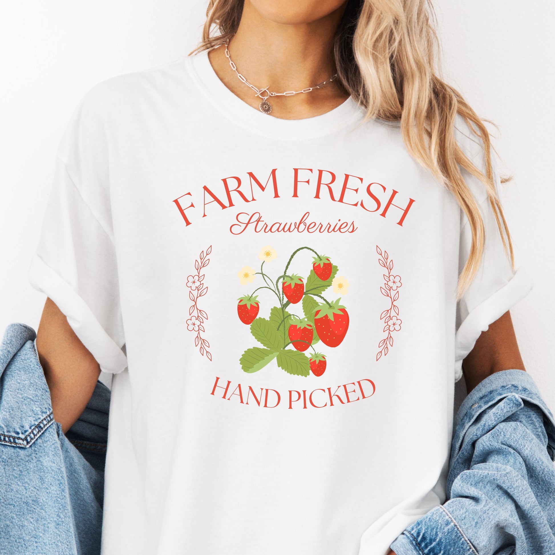 Person wearing a white t-shirt with 'Farm Fresh Strawberries Hand Picked' design.