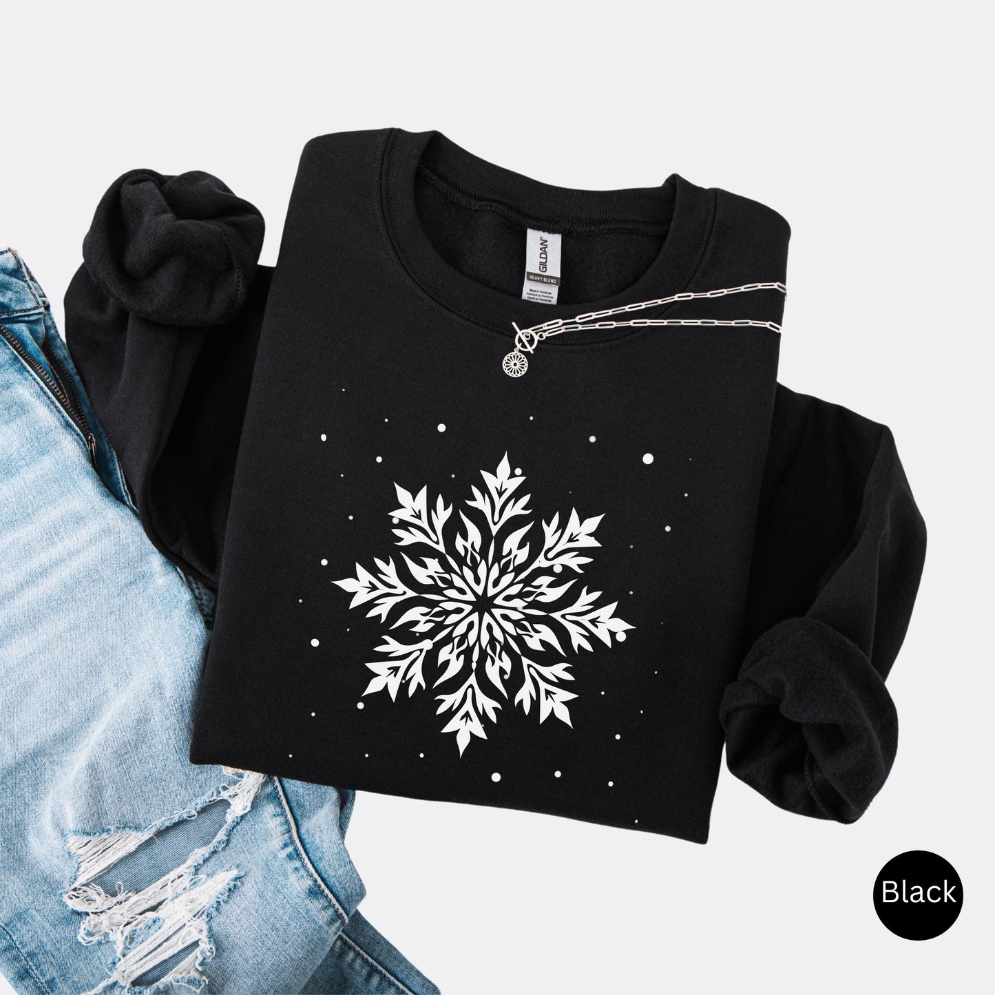 Snowflake design with falling snow on cozy unisex winter sweatshirt in the color black