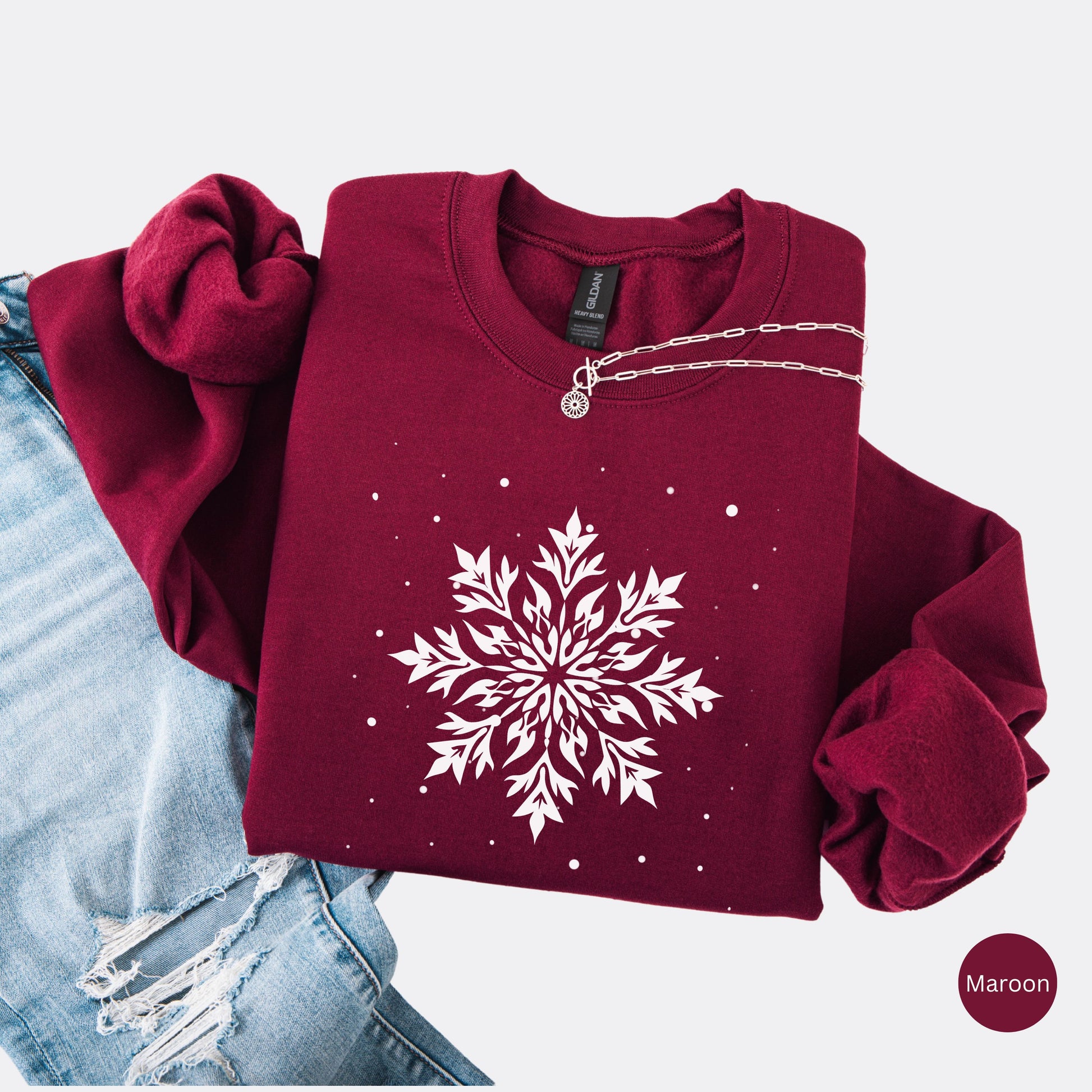 Snowflake design with falling snow on cozy unisex winter sweatshirt in the color maroon