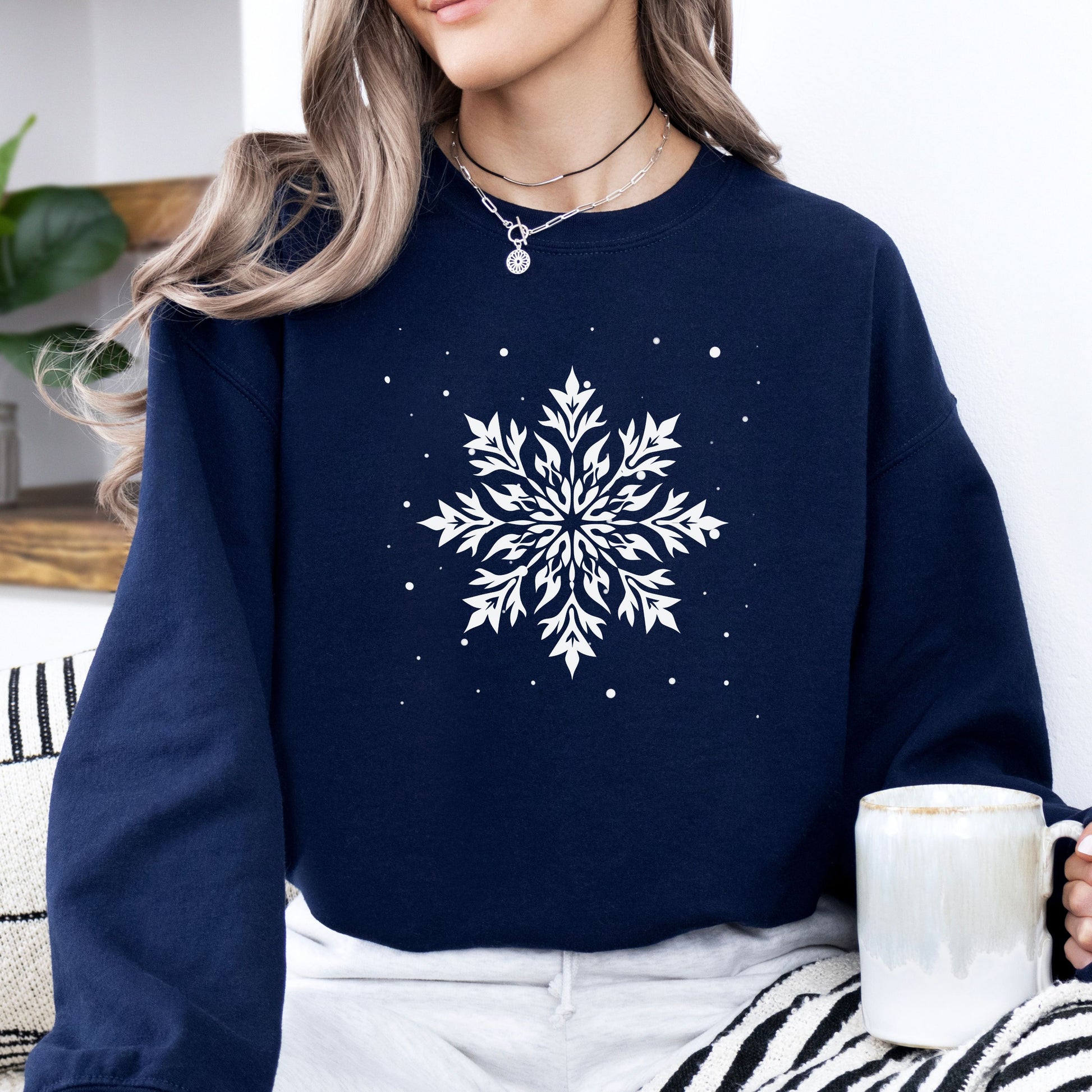 Person wearing snowflake design with falling snow on cozy unisex winter sweatshirt in the color navy