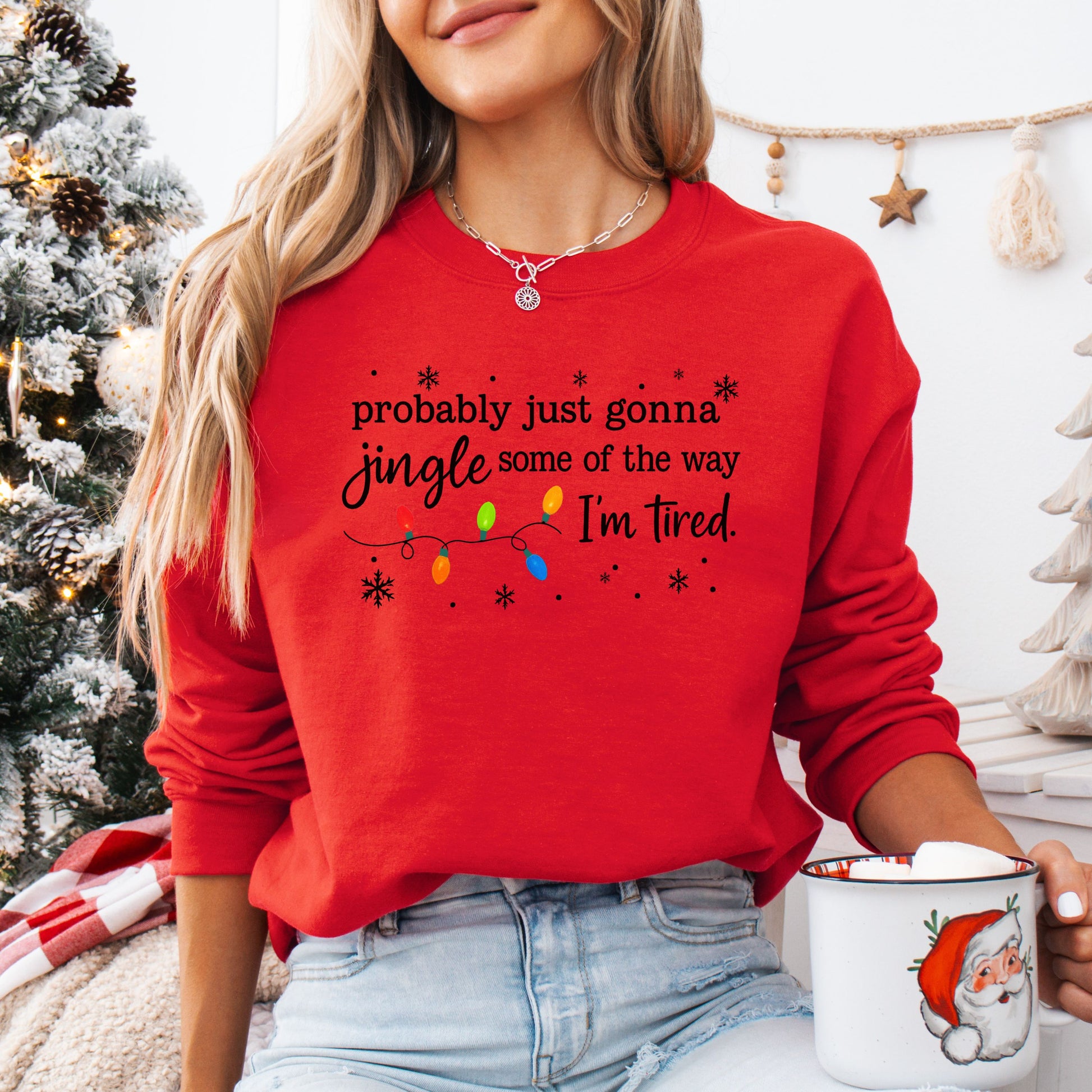 Person wearing a red sweatshirt with Christmas lights and the text "probably just gonna jingle some of the way I'm tired".