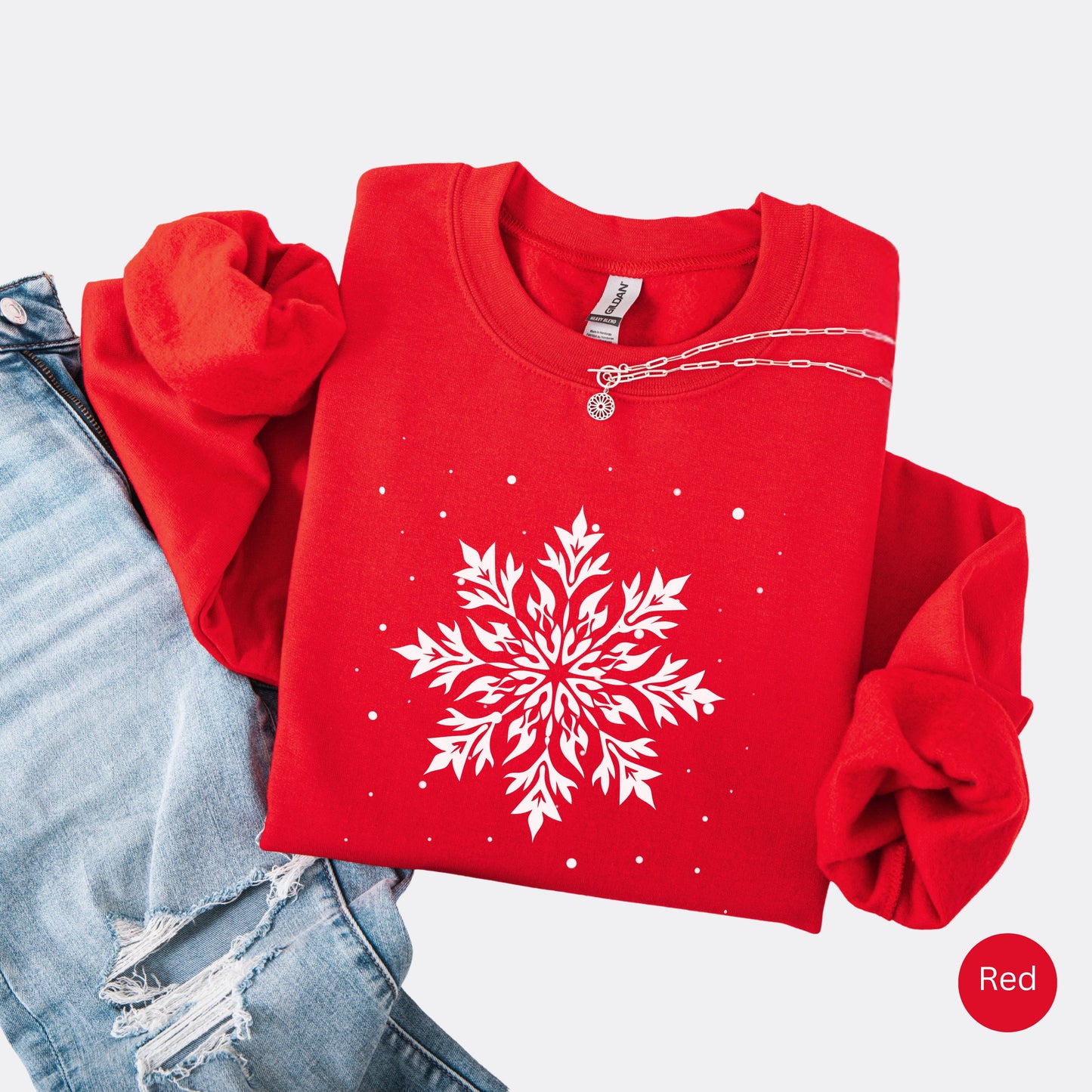 Snowflake design with falling snow on cozy unisex winter sweatshirt in the color red