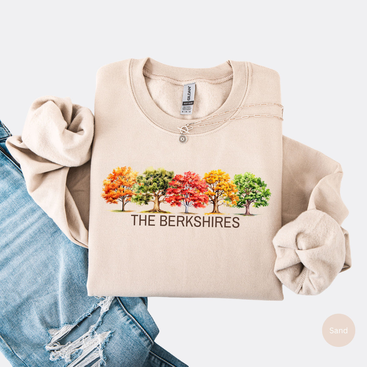 Sand colored crewneck sweatshirt featuring colorful watercolor trees above the words The Berkshires.