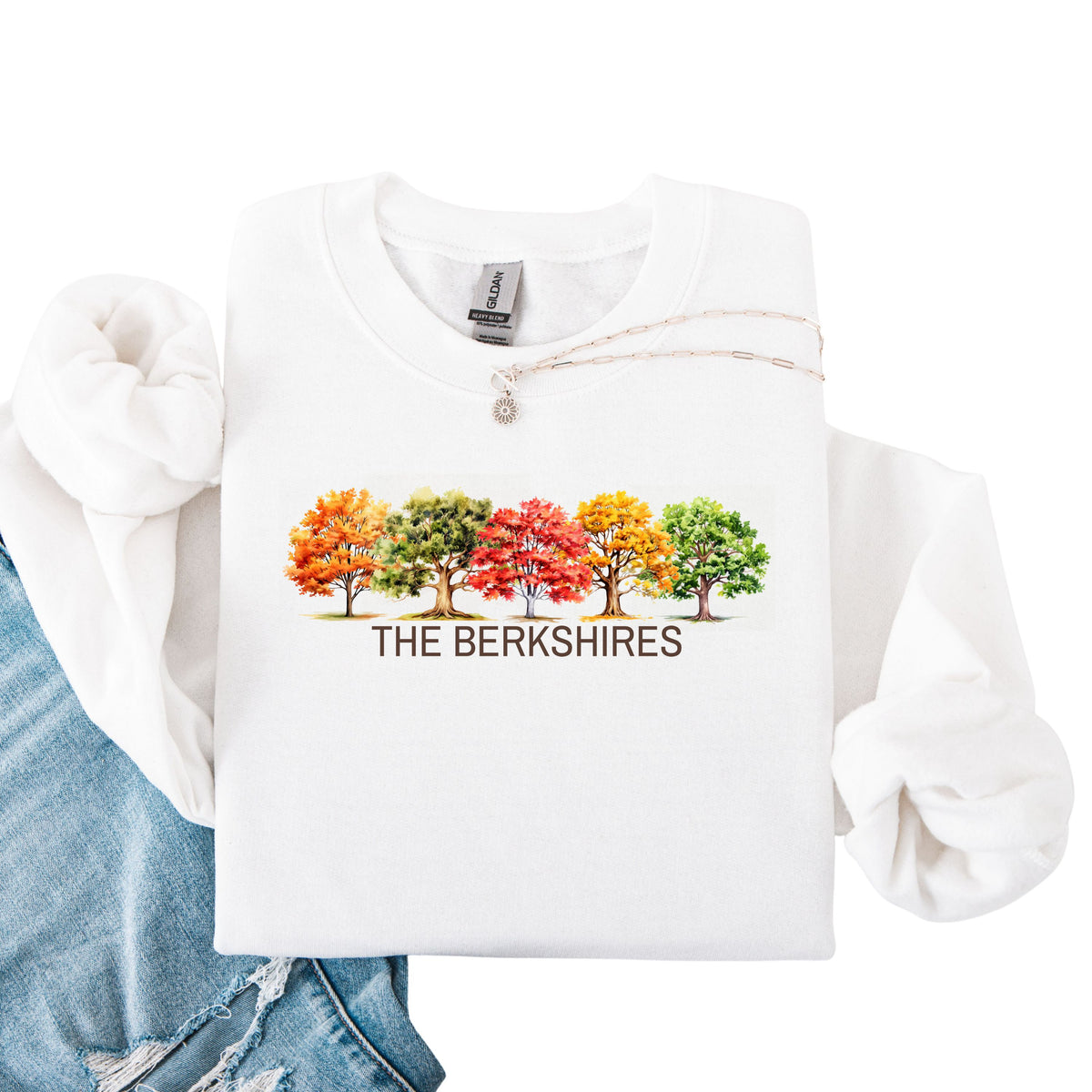 White crewneck sweatshirt featuring colorful watercolor trees above the words The Berkshires.