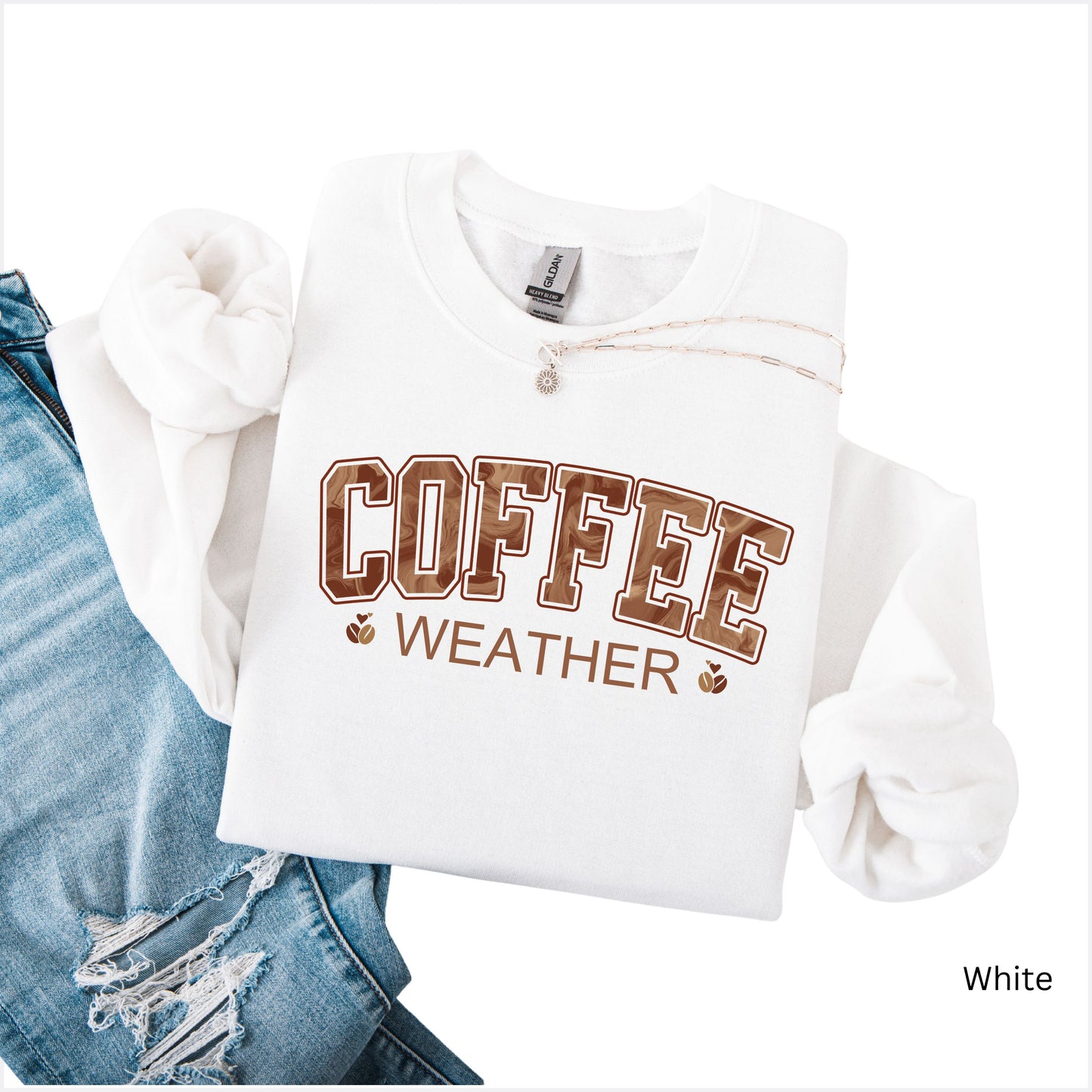 Coffee weather sweatshirt with marbled brown lettering and coffee bean icons on white crewneck.