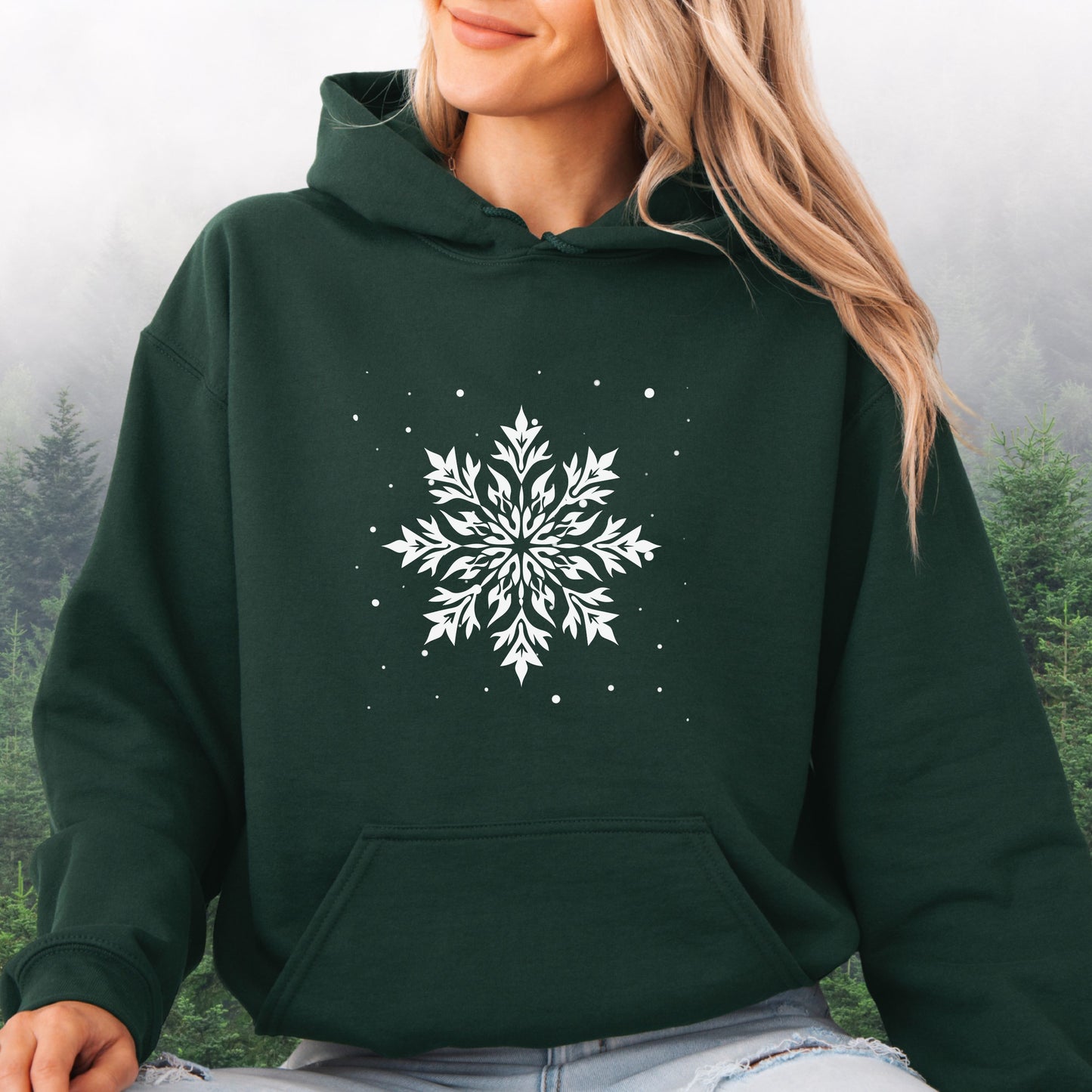Person wearing snowflake design with falling snow on cozy unisex hoodie in the color forest green