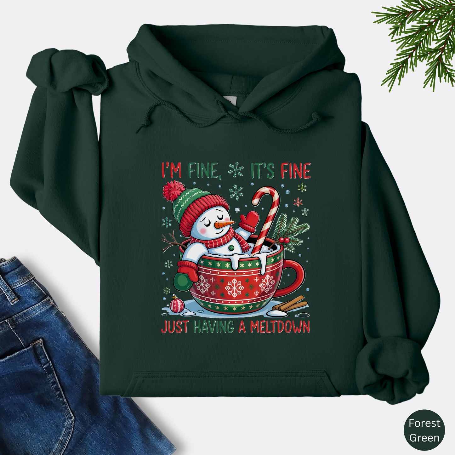 Snowman Christmas hoodie in the color forest green with festive mug design and text that reads I’m Fine It’s Fine Just Having a Meltdown.