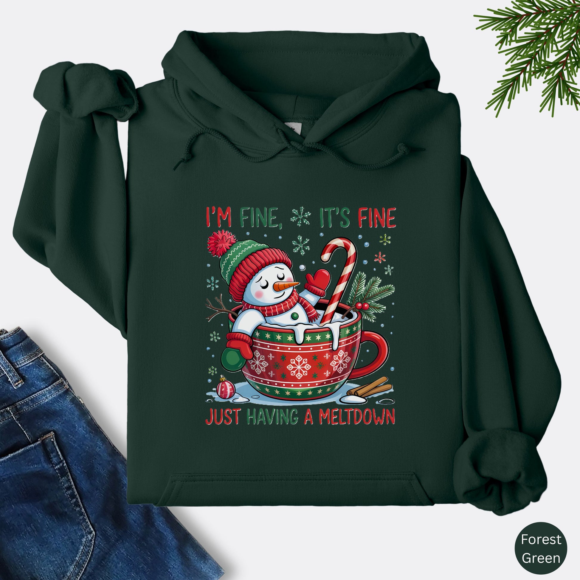 Snowman Christmas hoodie in the color forest green with festive mug design and text that reads I’m Fine It’s Fine Just Having a Meltdown.