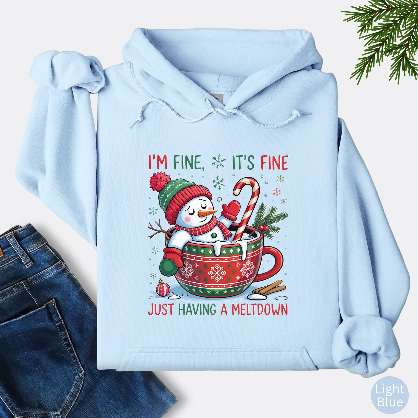 Snowman Christmas hoodie in the color light blue with festive mug design and text that reads I’m Fine It’s Fine Just Having a Meltdown.