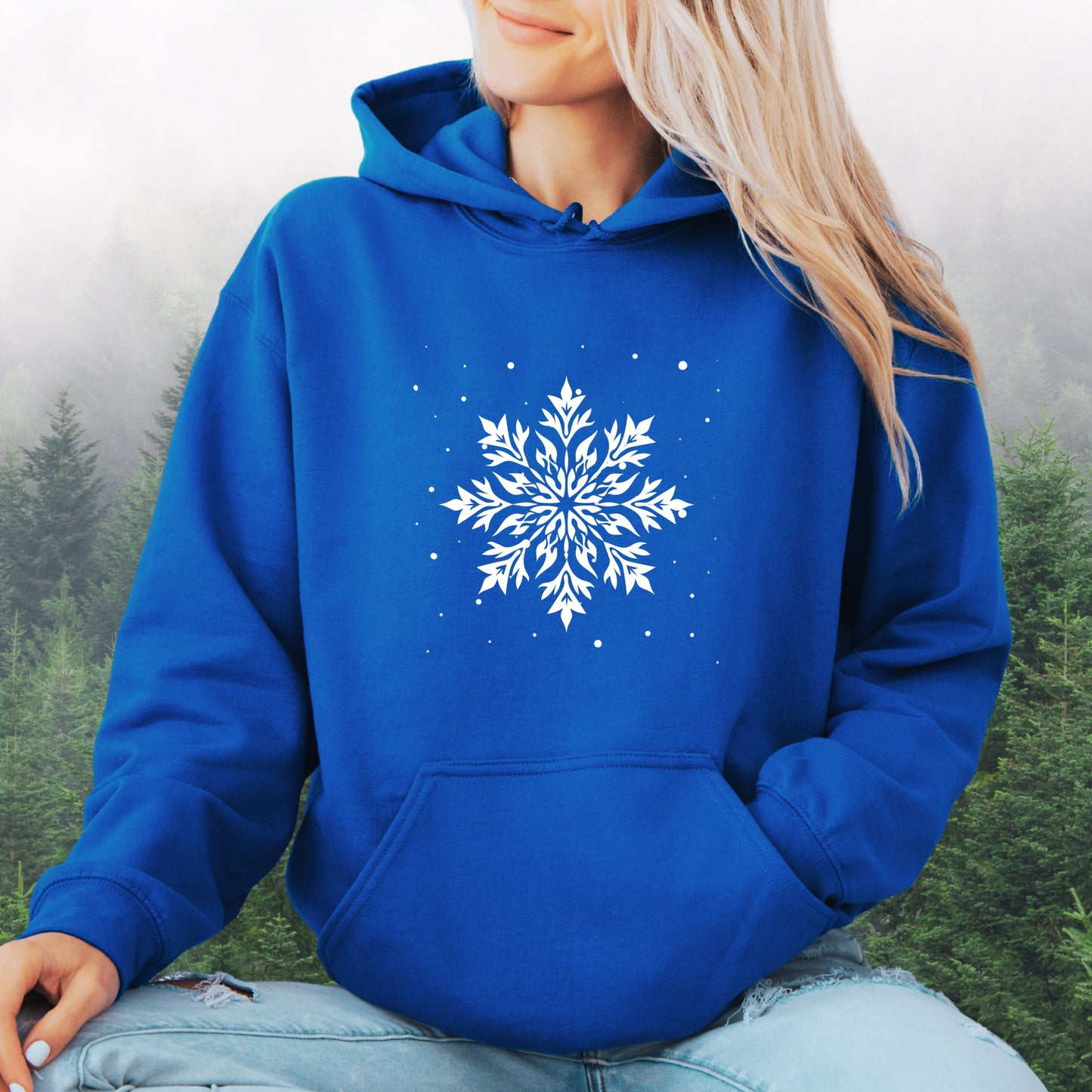 Person wearing snowflake design with falling snow on cozy unisex hoodie in the color royal blue