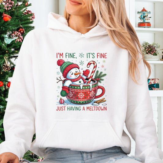 Person wearing white Snowman Christmas hoodie with festive mug design and text that reads I’m Fine It’s Fine Just Having a Meltdown.
