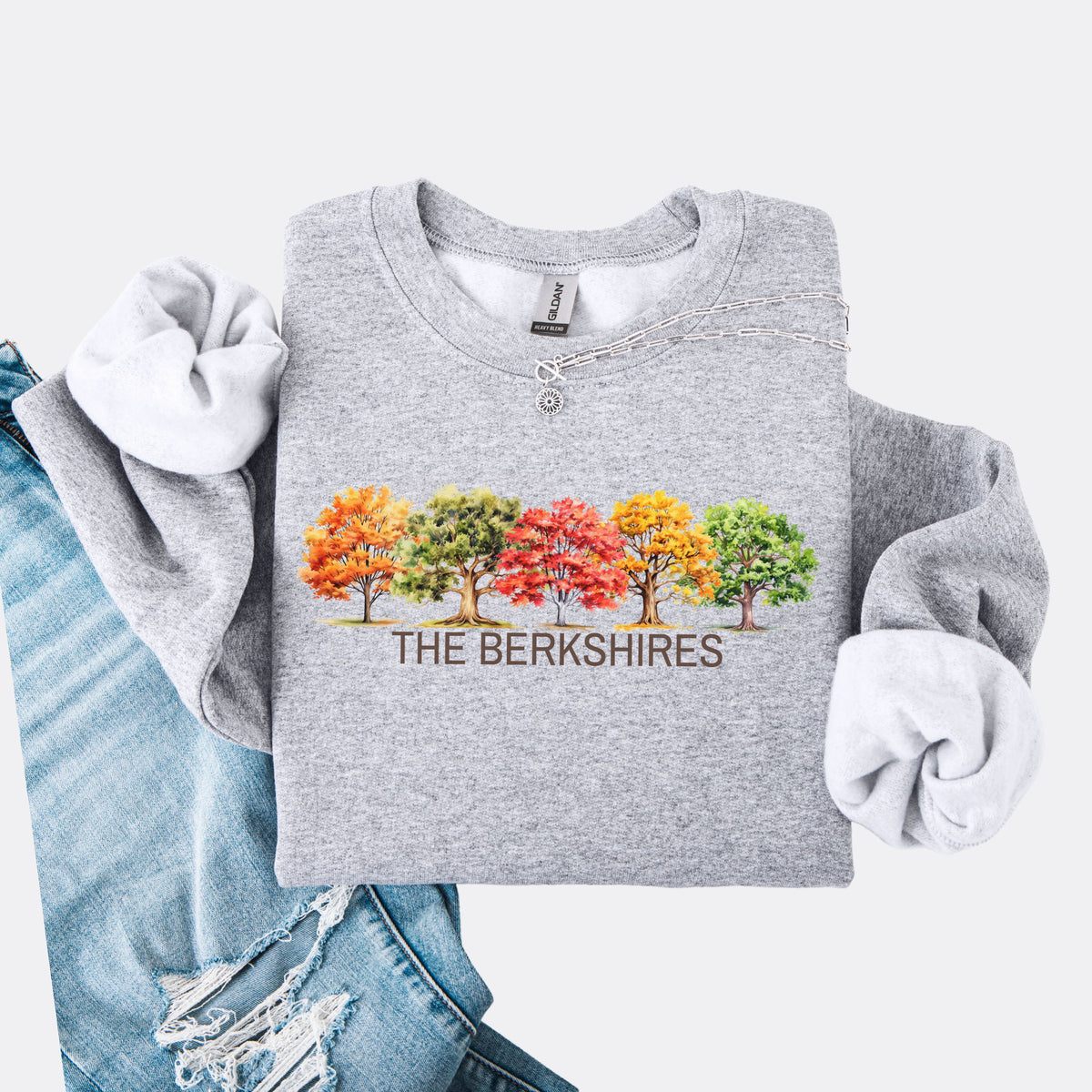 Grey crewneck sweatshirt featuring colorful watercolor trees above the words The Berkshires.