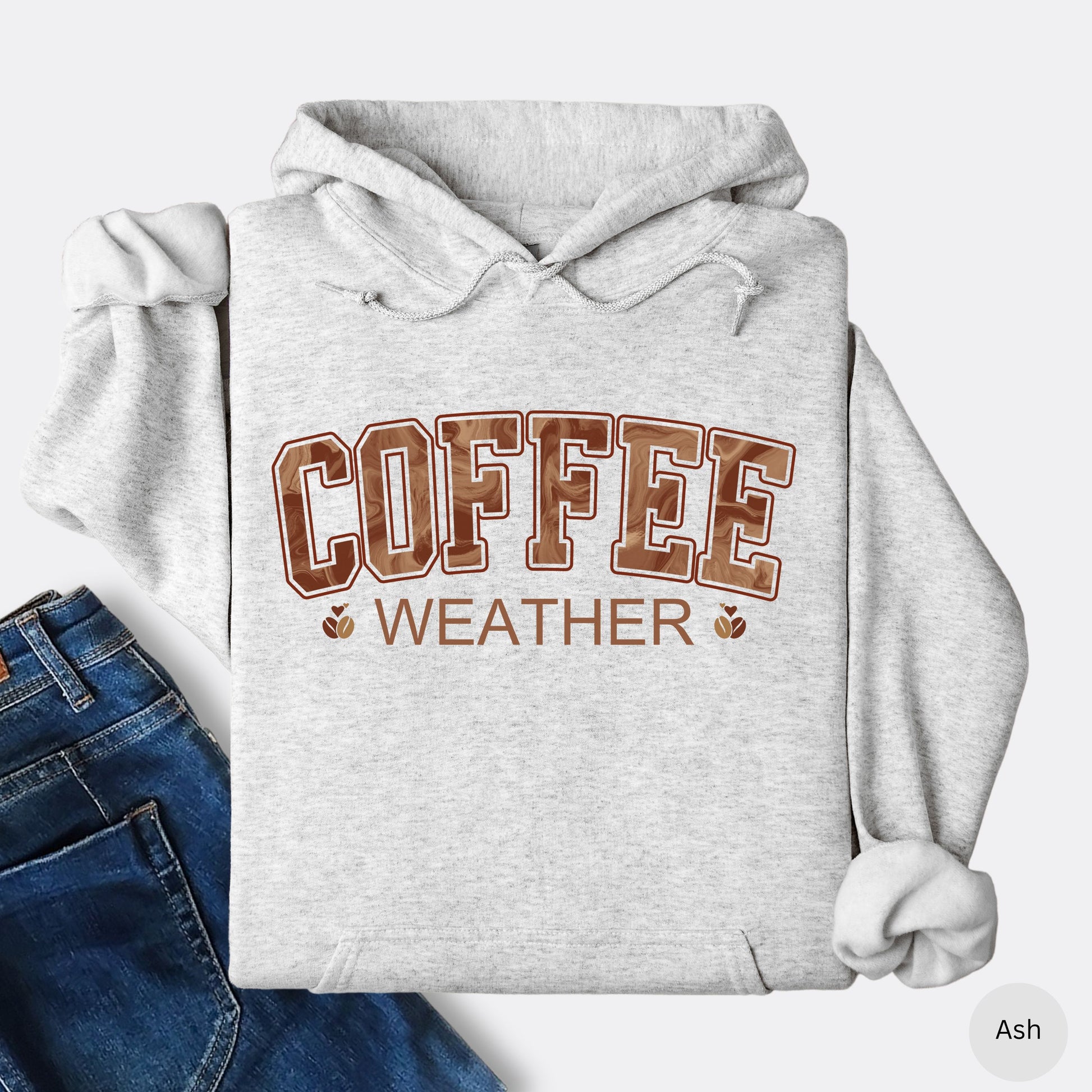 Ash colored coffee weather hoodie with marbled brown lettering and coffee bean icons.
