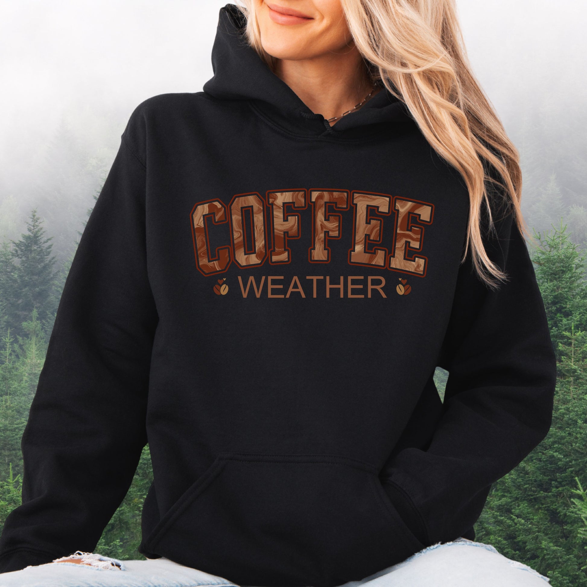 Person wearing black coffee weather hoodie with marbled brown lettering and coffee bean icons.