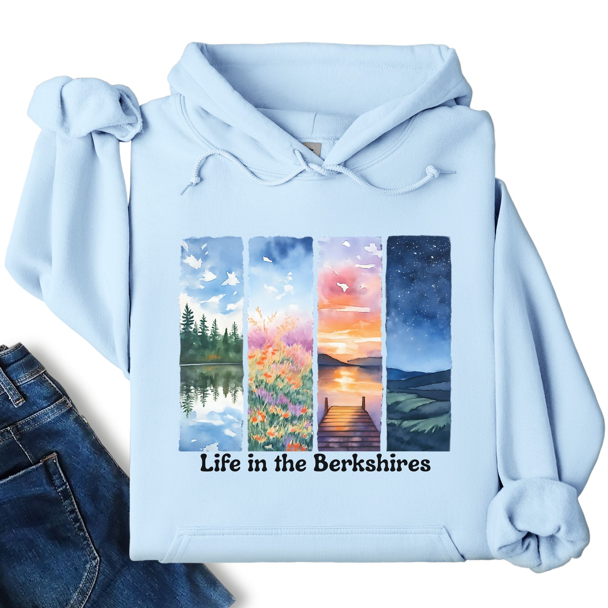 Life in the Berkshires hoodie laid flat showing scenic landscape panel graphic on the front in light blue