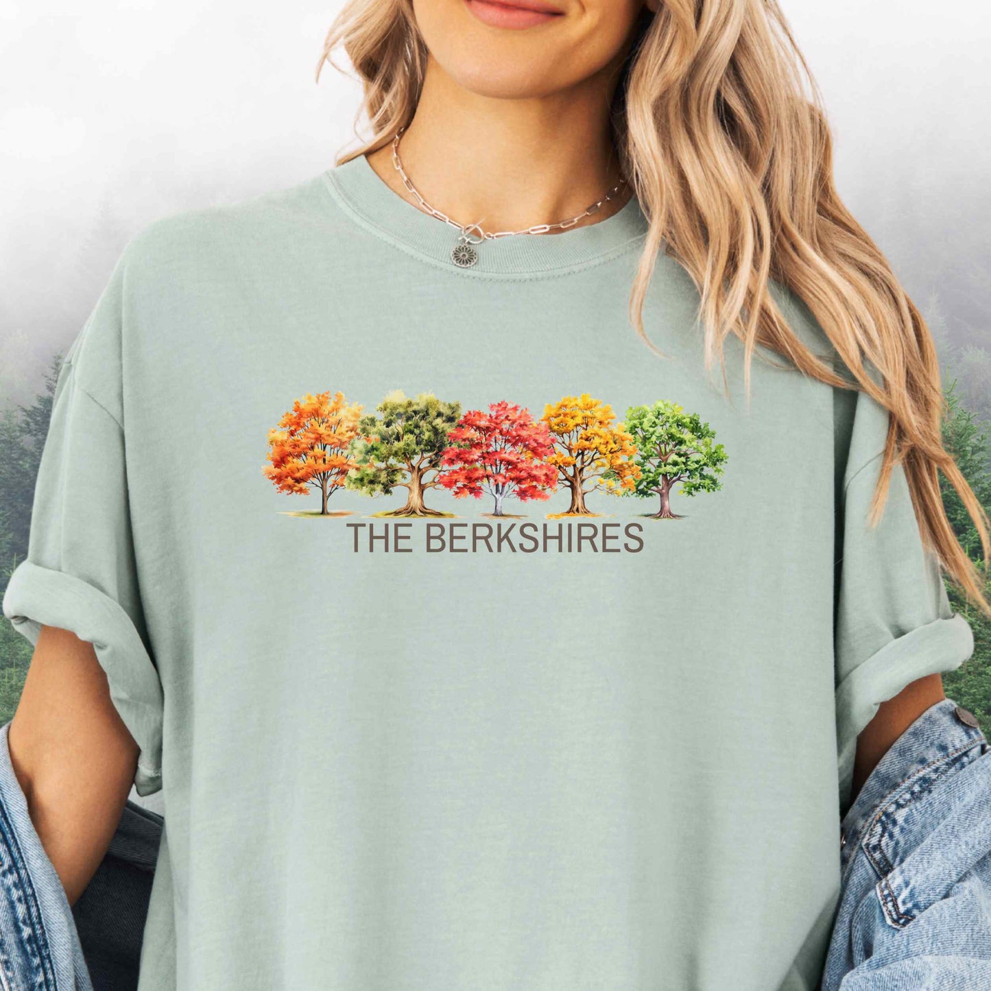 Person wearing The Berkshires Fall t-shirt with autumn trees in the color bay