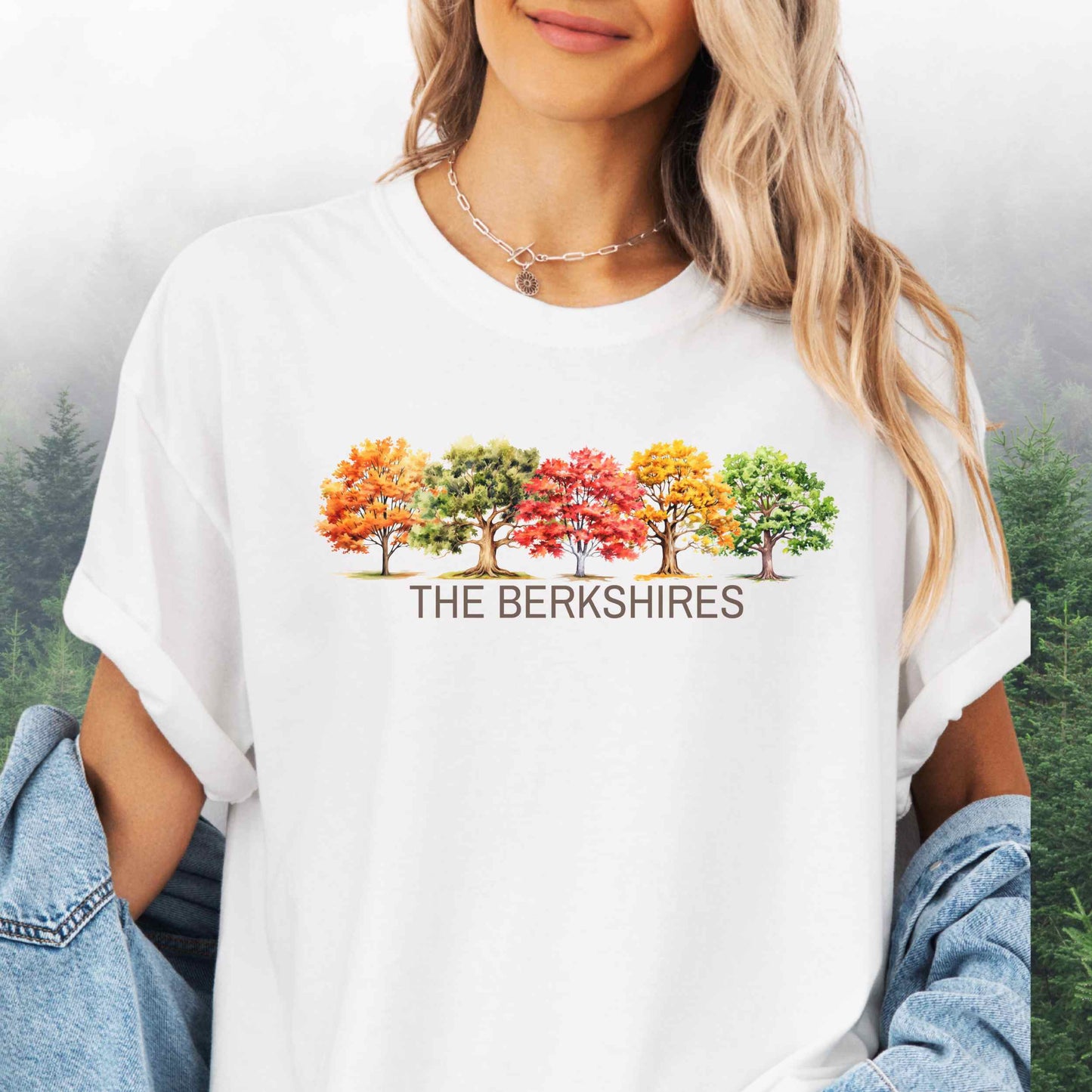 Person wearing The Berkshires Fall t-shirt with autumn trees in the color white.
