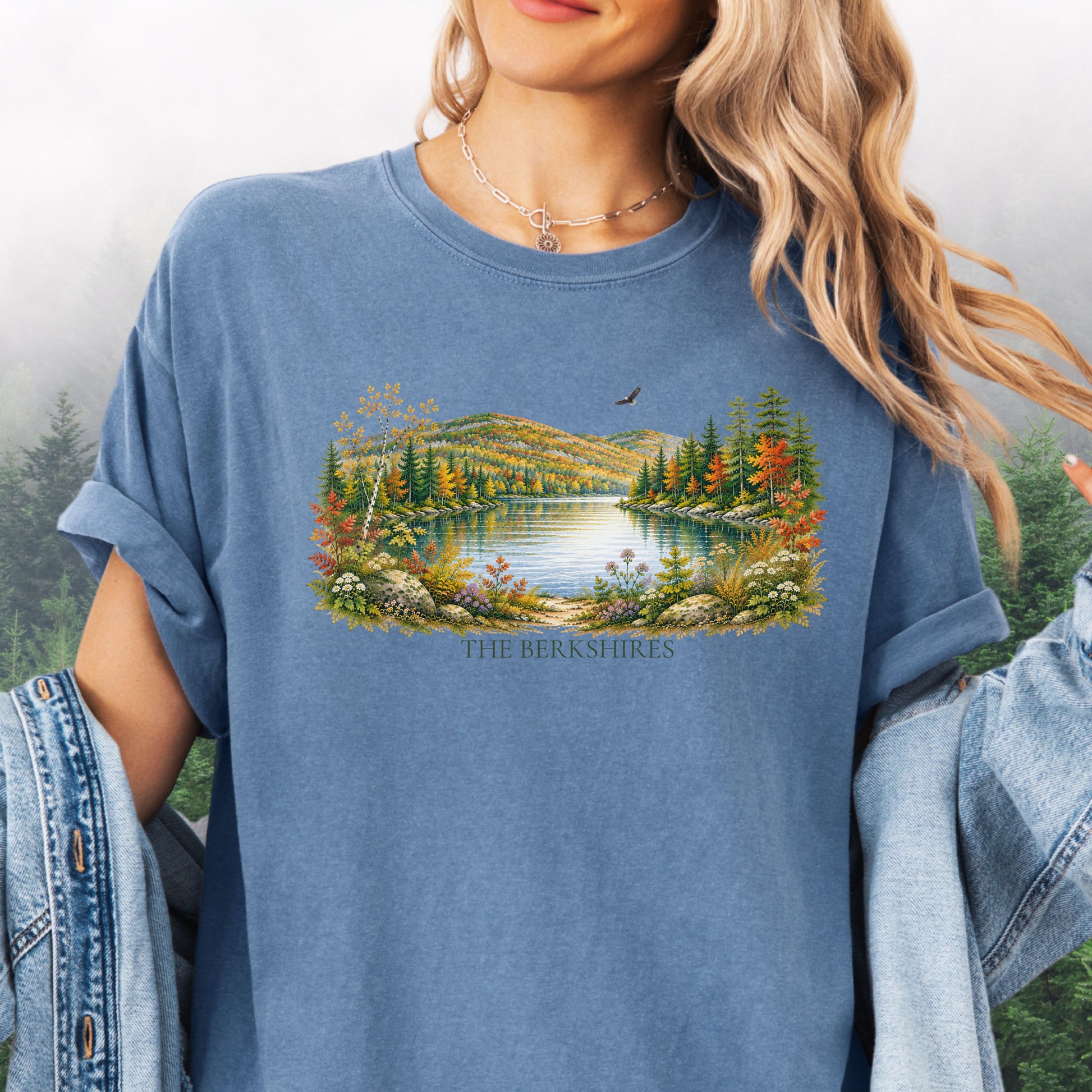 Person wearing The Berkshires autumn landscape Comfort Colors T-shirt with colorful fall foliage, mountains, lake and eagle in the color blue jean.