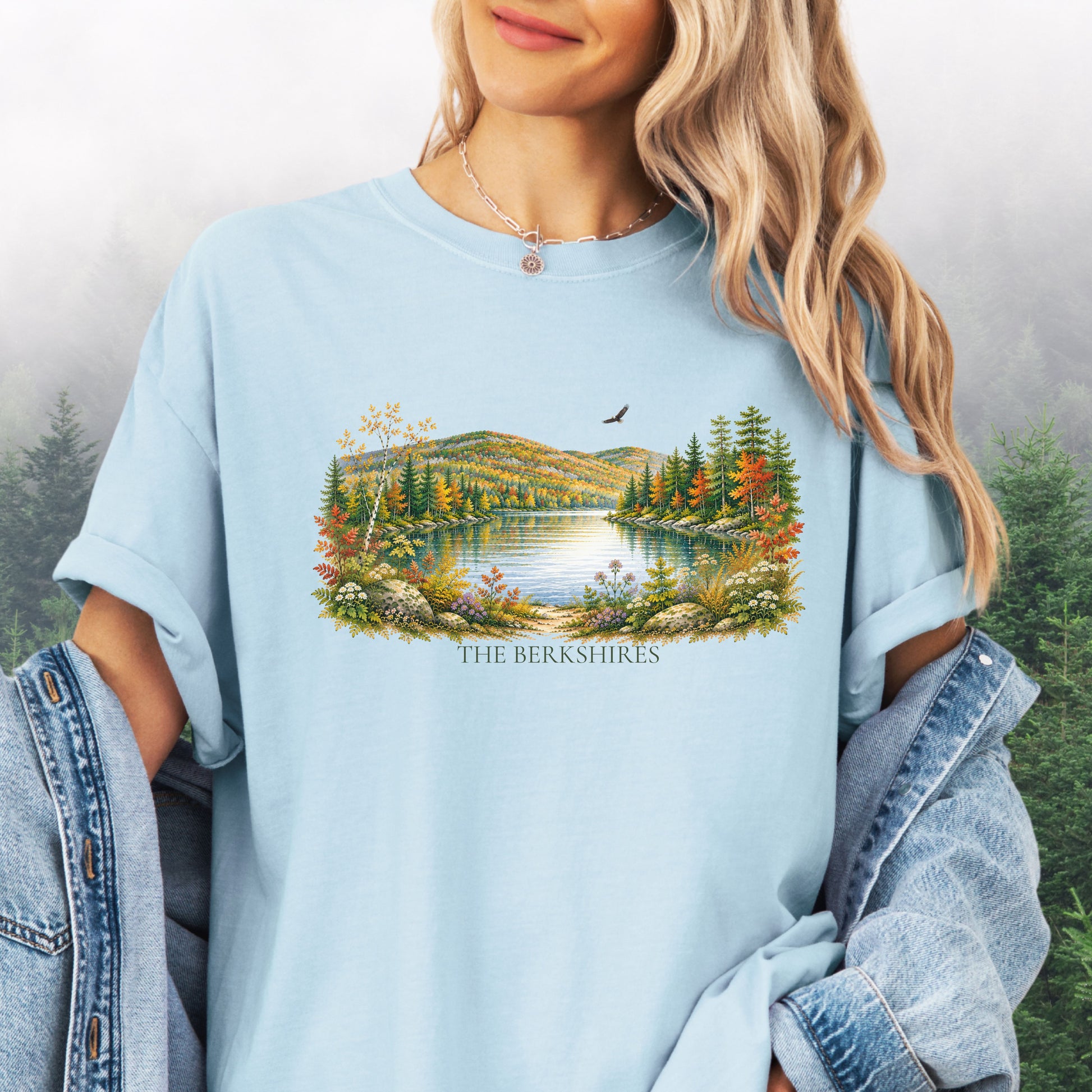 Person wearing The Berkshires autumn landscape Comfort Colors T-shirt with colorful fall foliage, mountains, lake and eagle in the color chambray