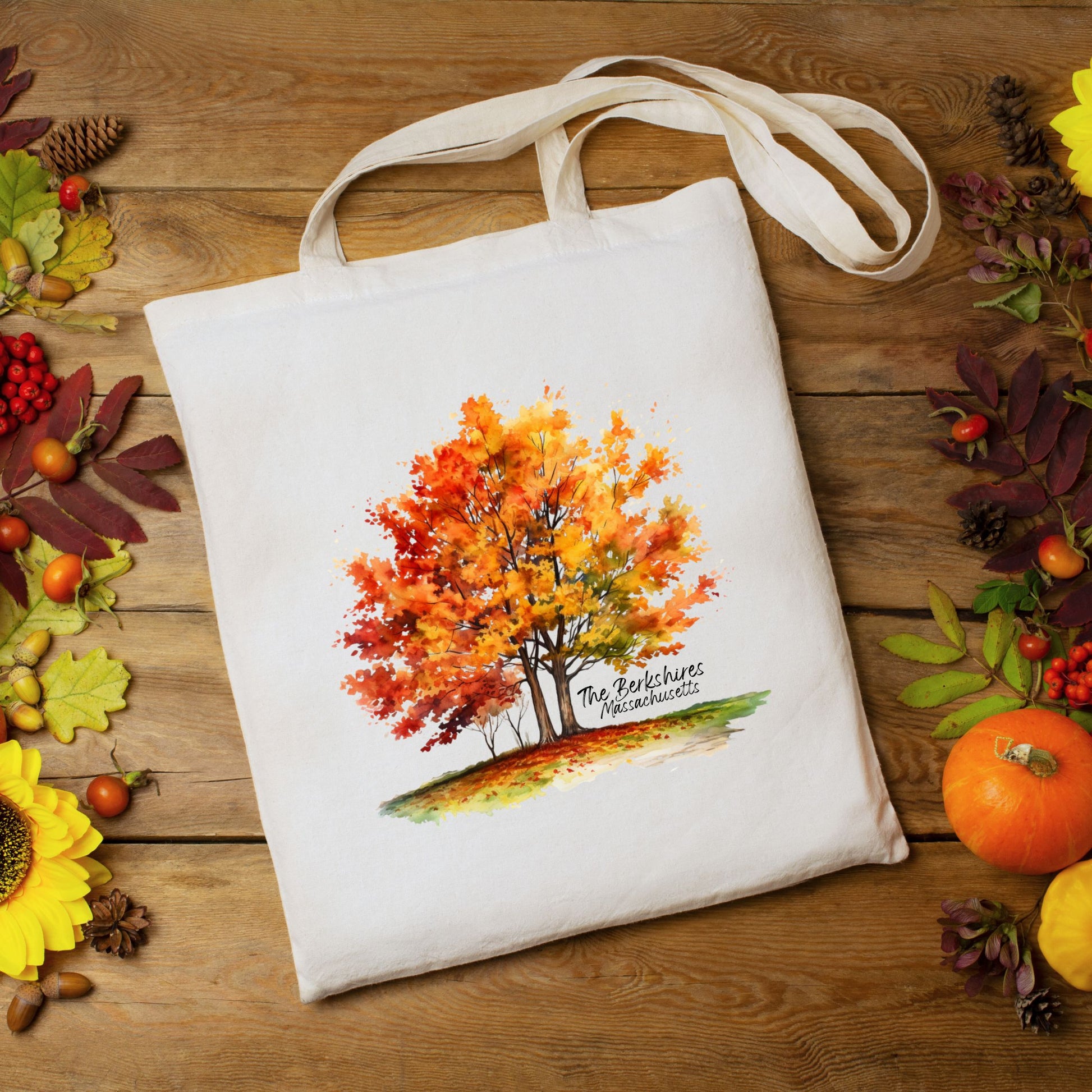 Flat lay of a cotton tote bag with a watercolor maple tree design and the text “The Berkshires Massachusetts” printed on the front.