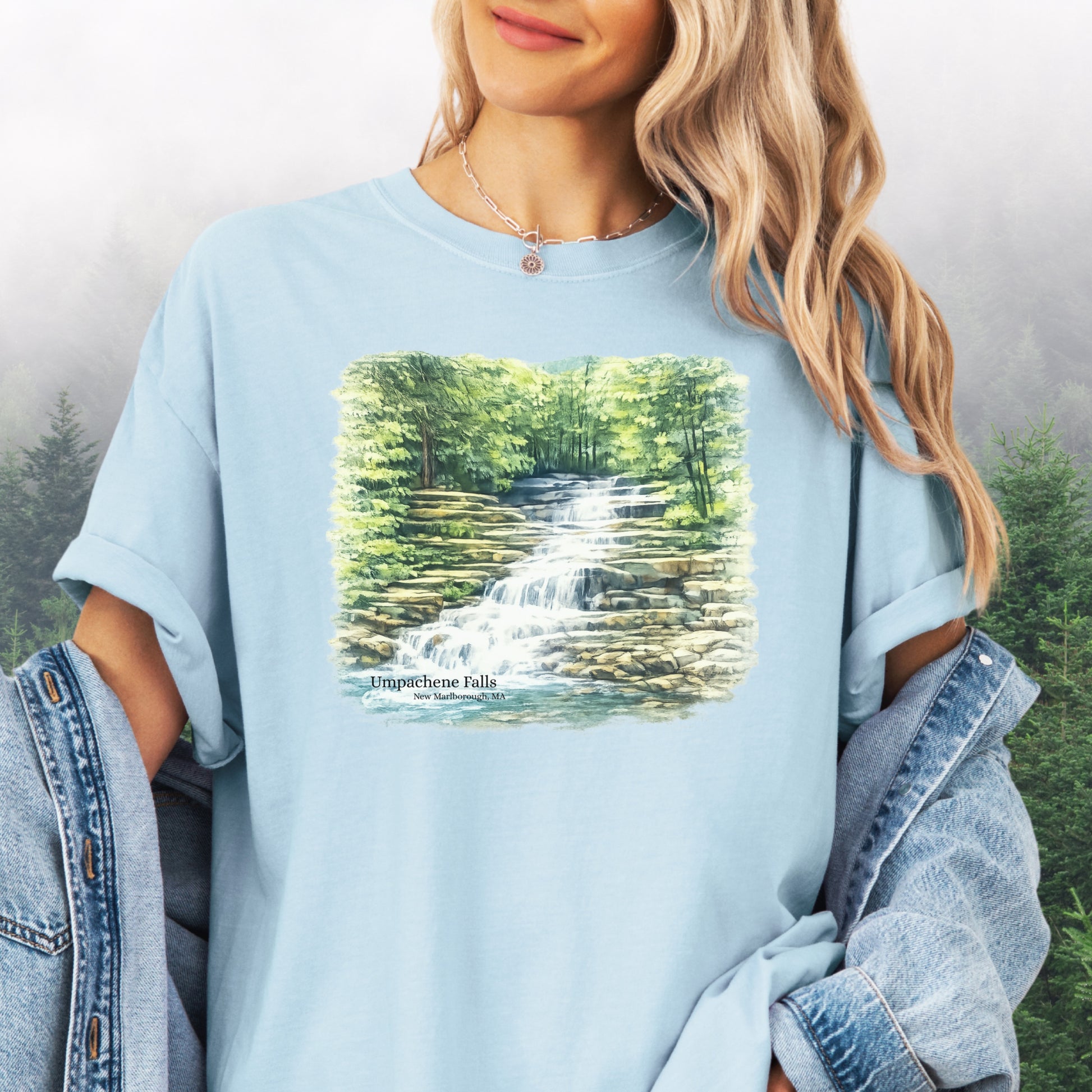 Person wearing Umpachene Falls Comfort Colors t-shirt with waterfall design in the color chambray