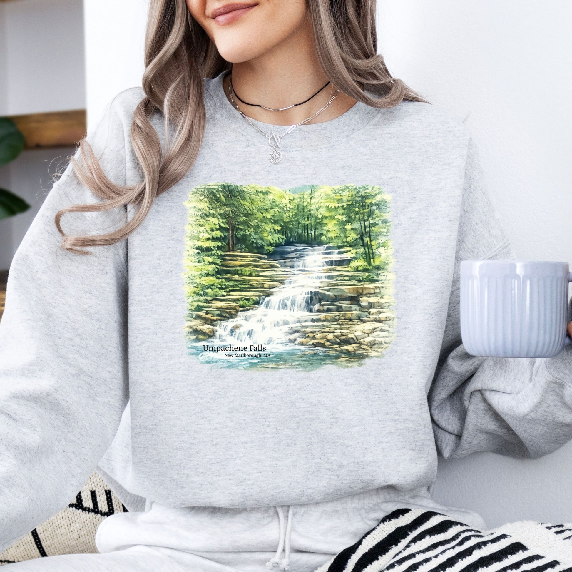 Person wearing Umpachene Falls crewneck sweatshirt with waterfall design in the color ash