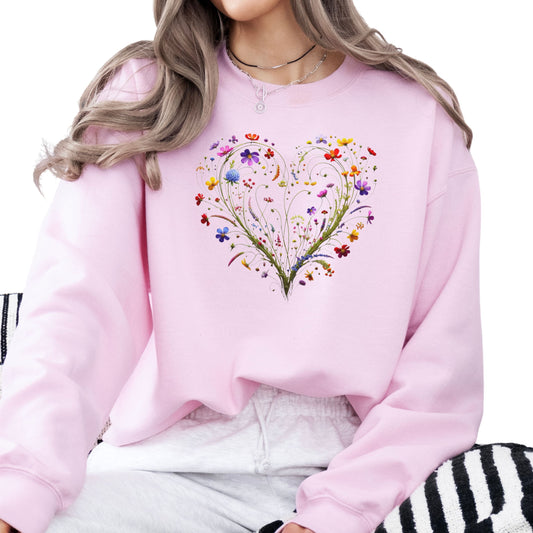 Person wearing pink sweatshirt featuring a floral heart design