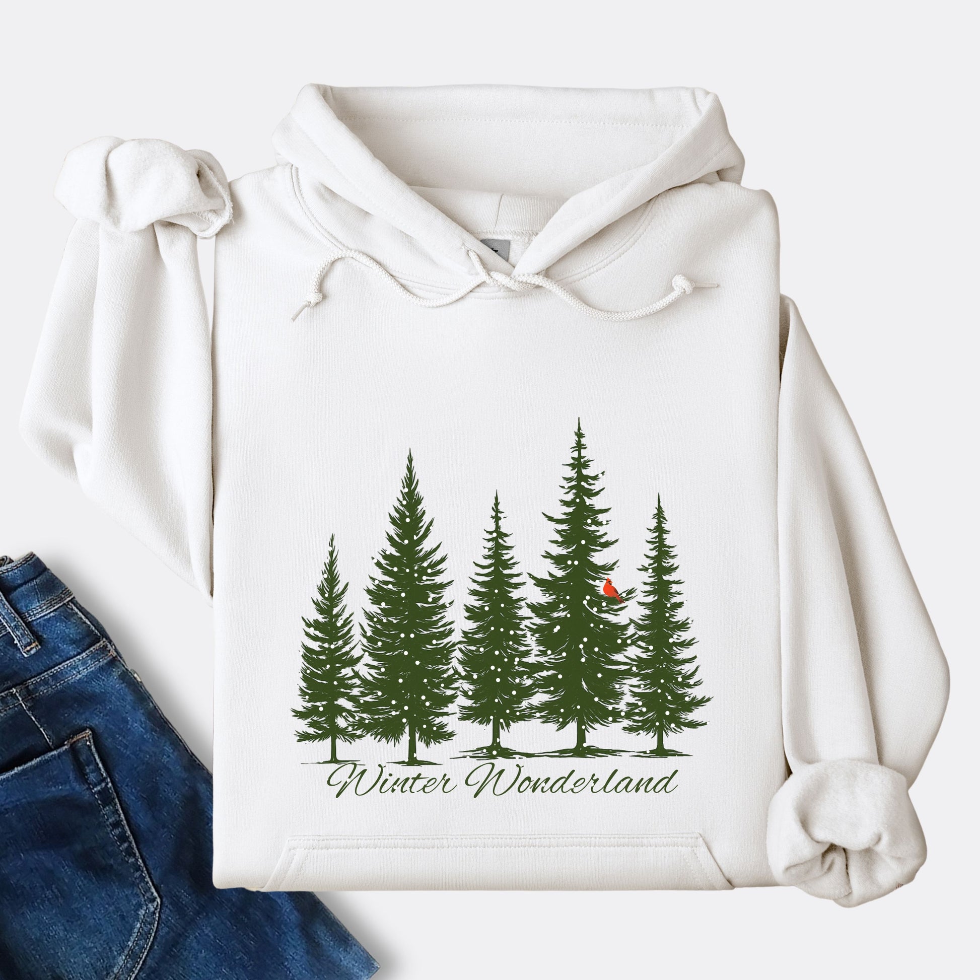 Snowy pine trees and red cardinal design on cozy unisex winter hoodie in the color white